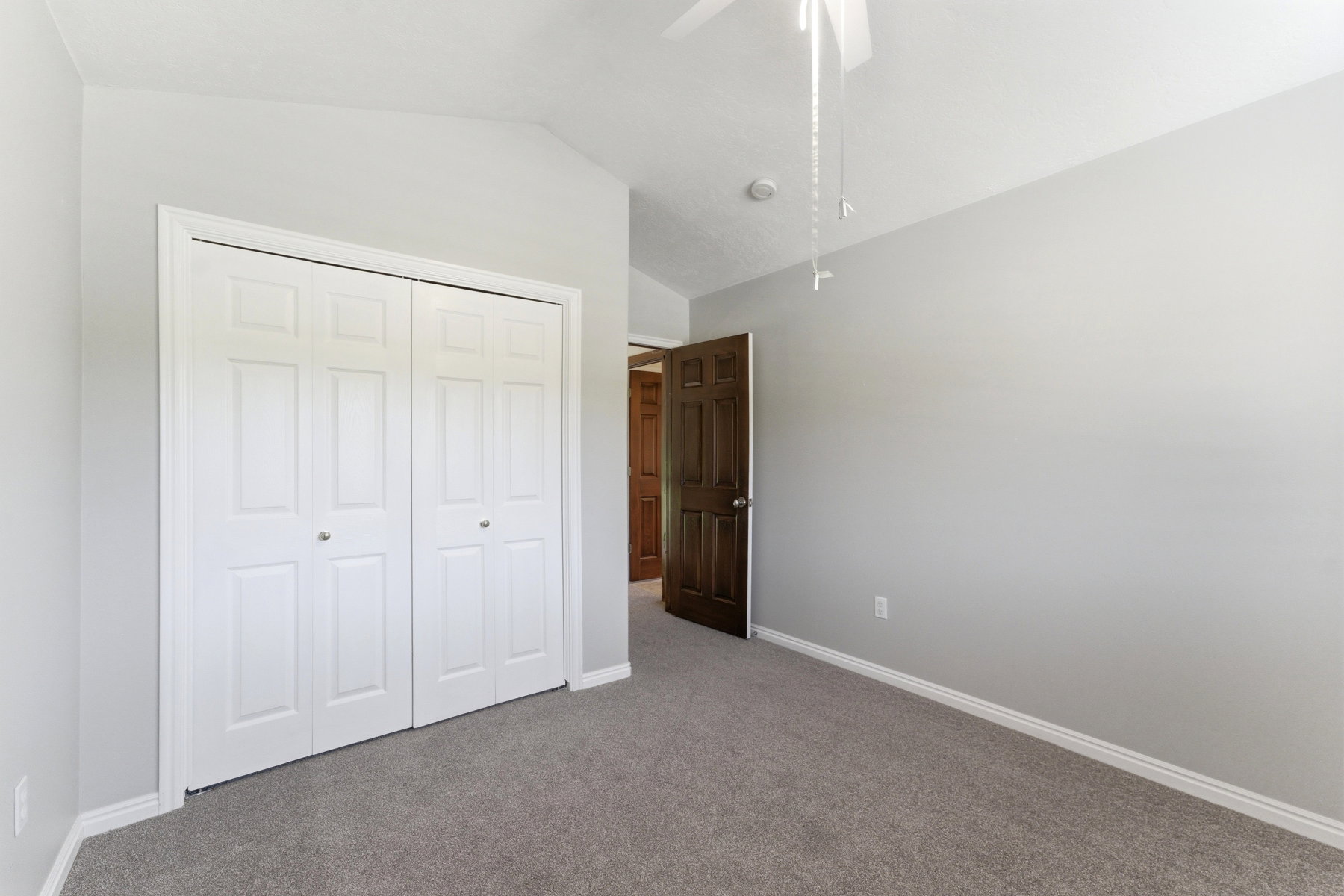Bedroom featuring light gray wall paint, gray carpet flooring, and white baseboards