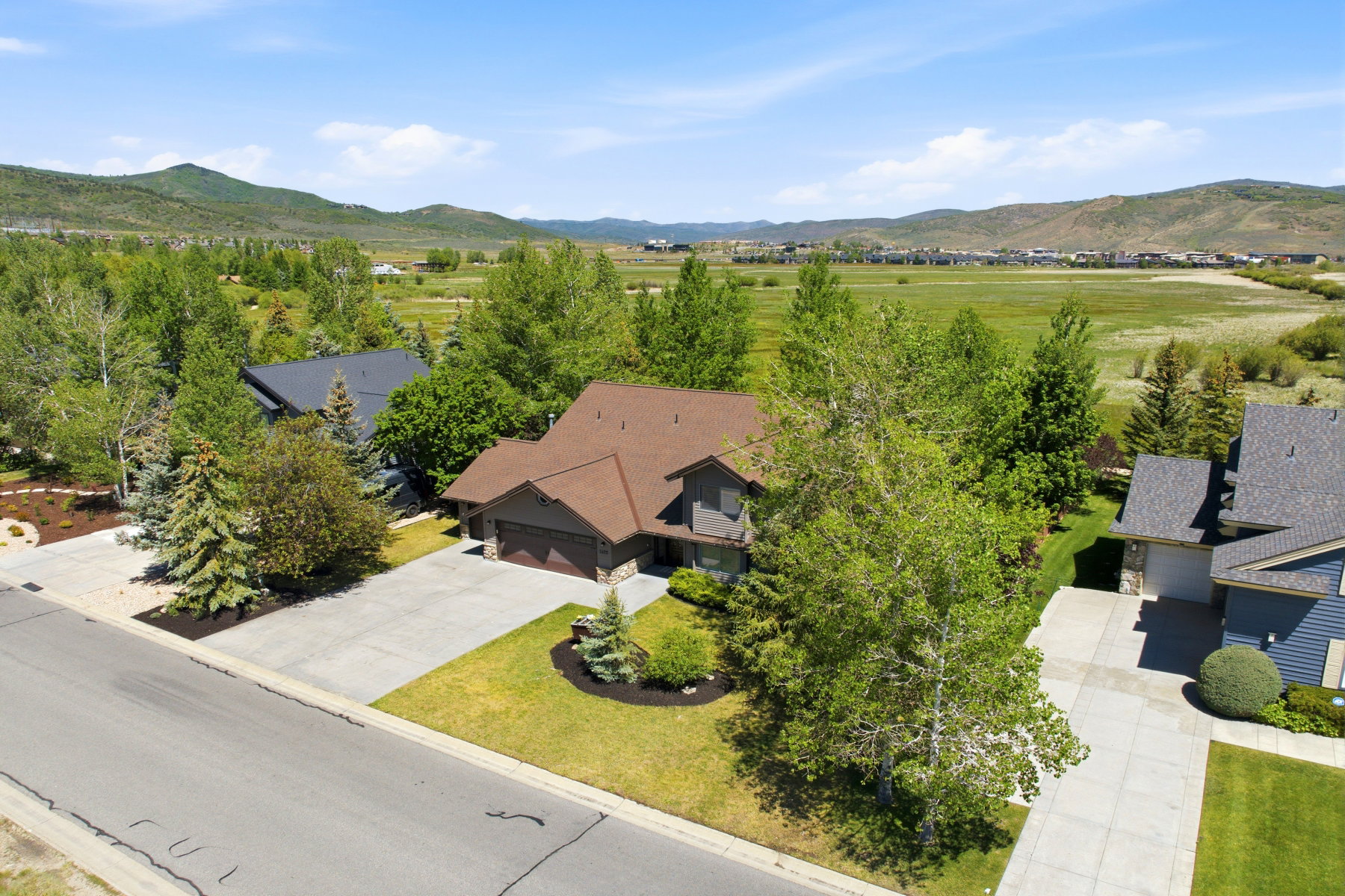 Traditional-style residence with a brown shingle roof and a two-car garage