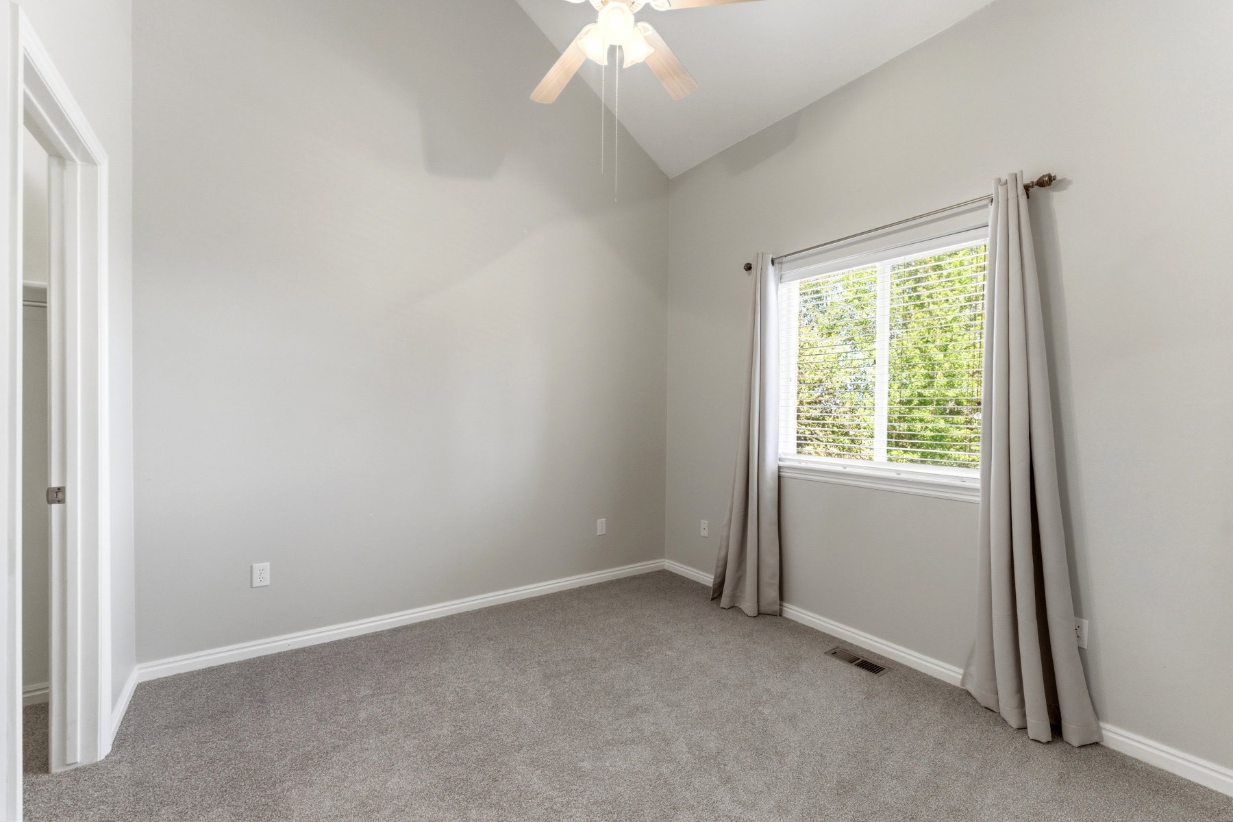 Vaulted ceilings complement the neutral wall tones and plush carpet flooring