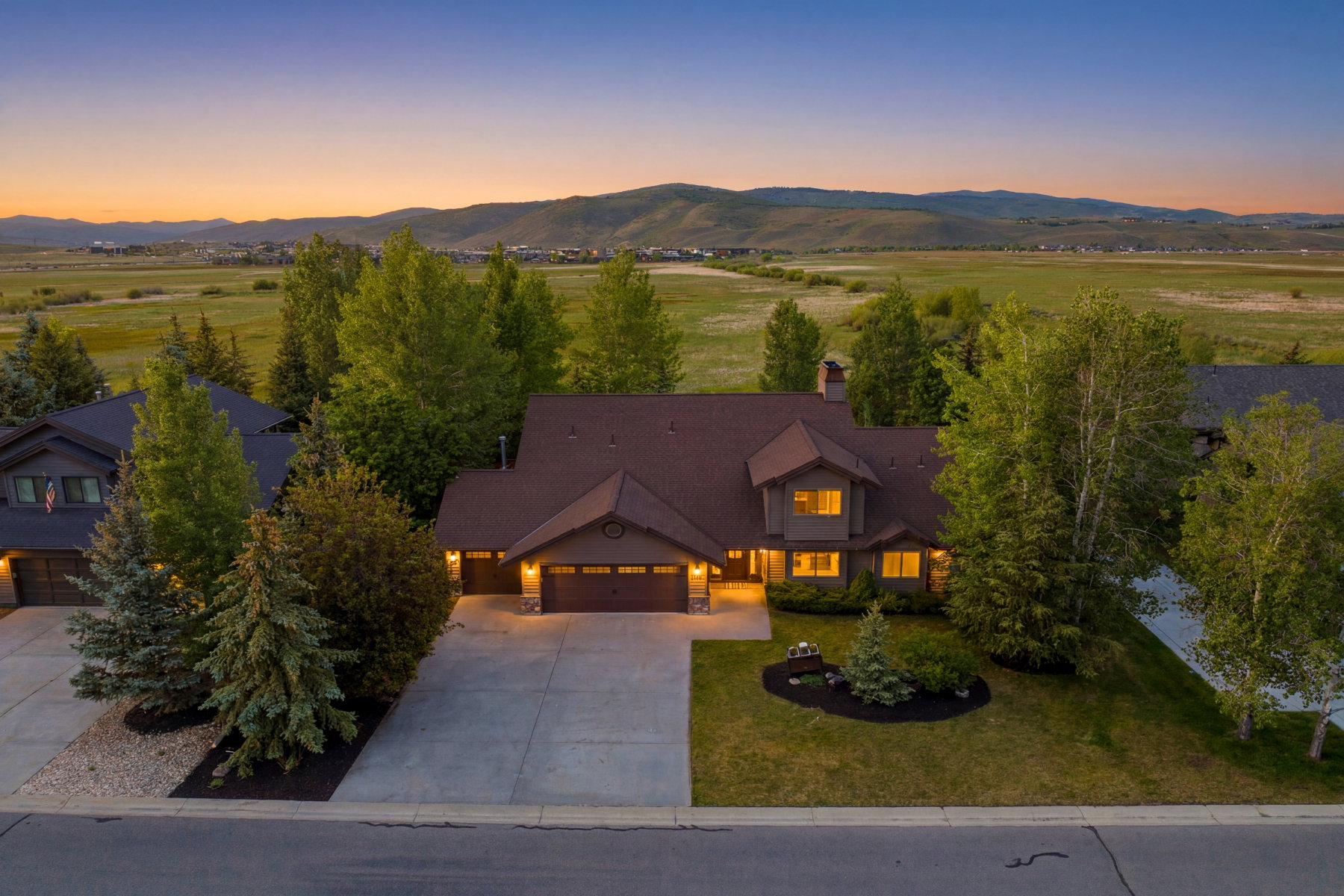 Contemporary-style residence featuring a dark brown exterior with stone accents and a multi-gabled roof
