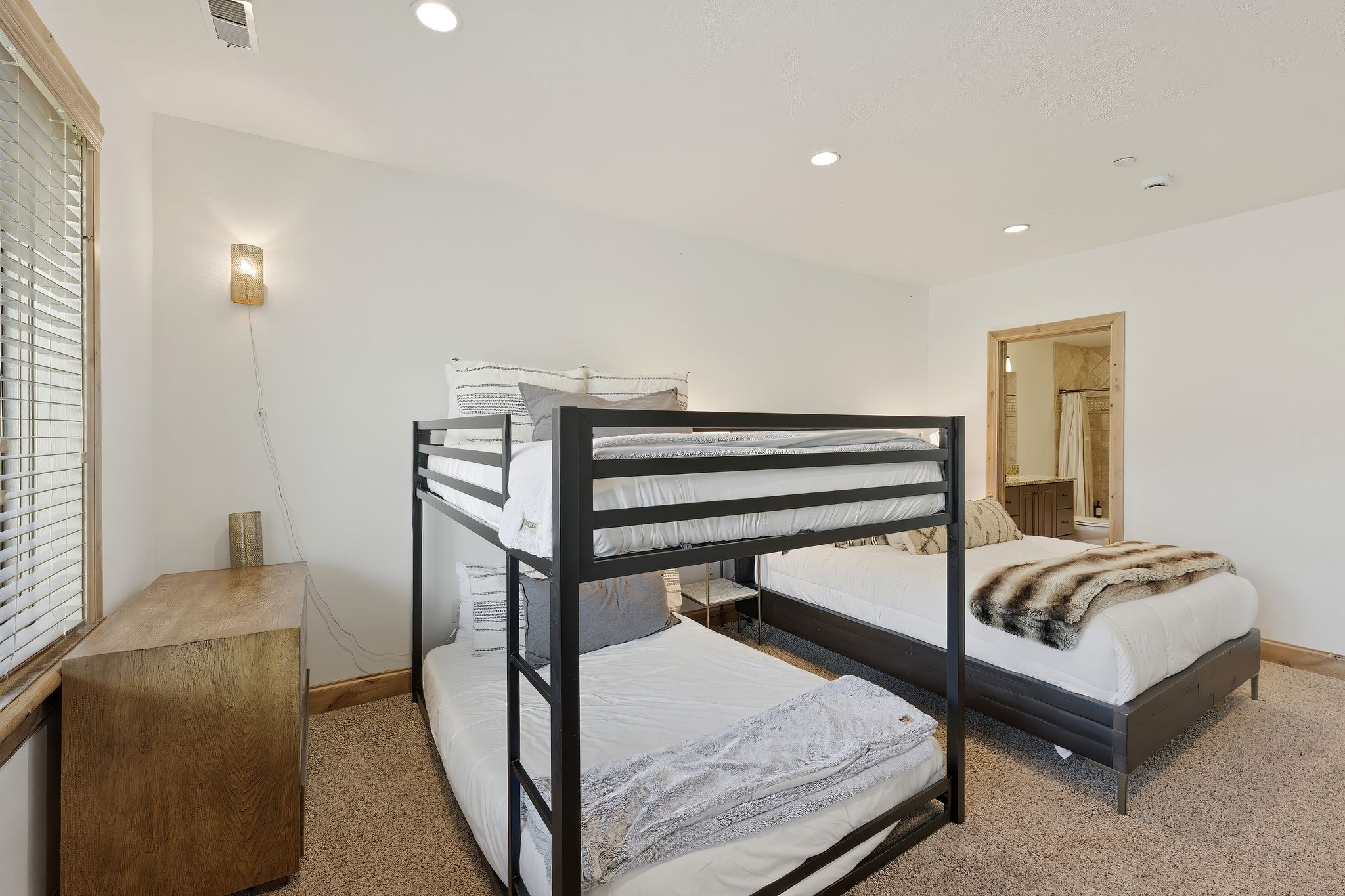 Carpeted room featuring a window with blinds, a wood-finish dresser, and recessed lighting
