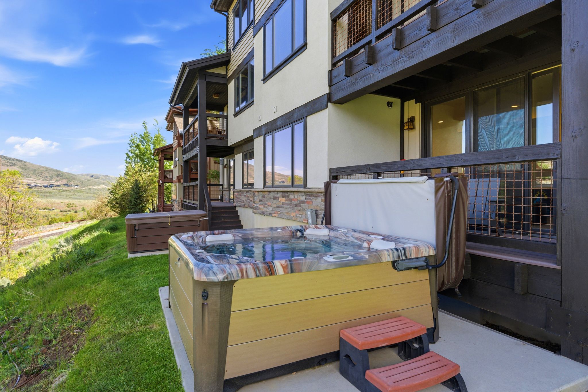Patio featuring a built-in spa, concrete slab, and stone veneer accents