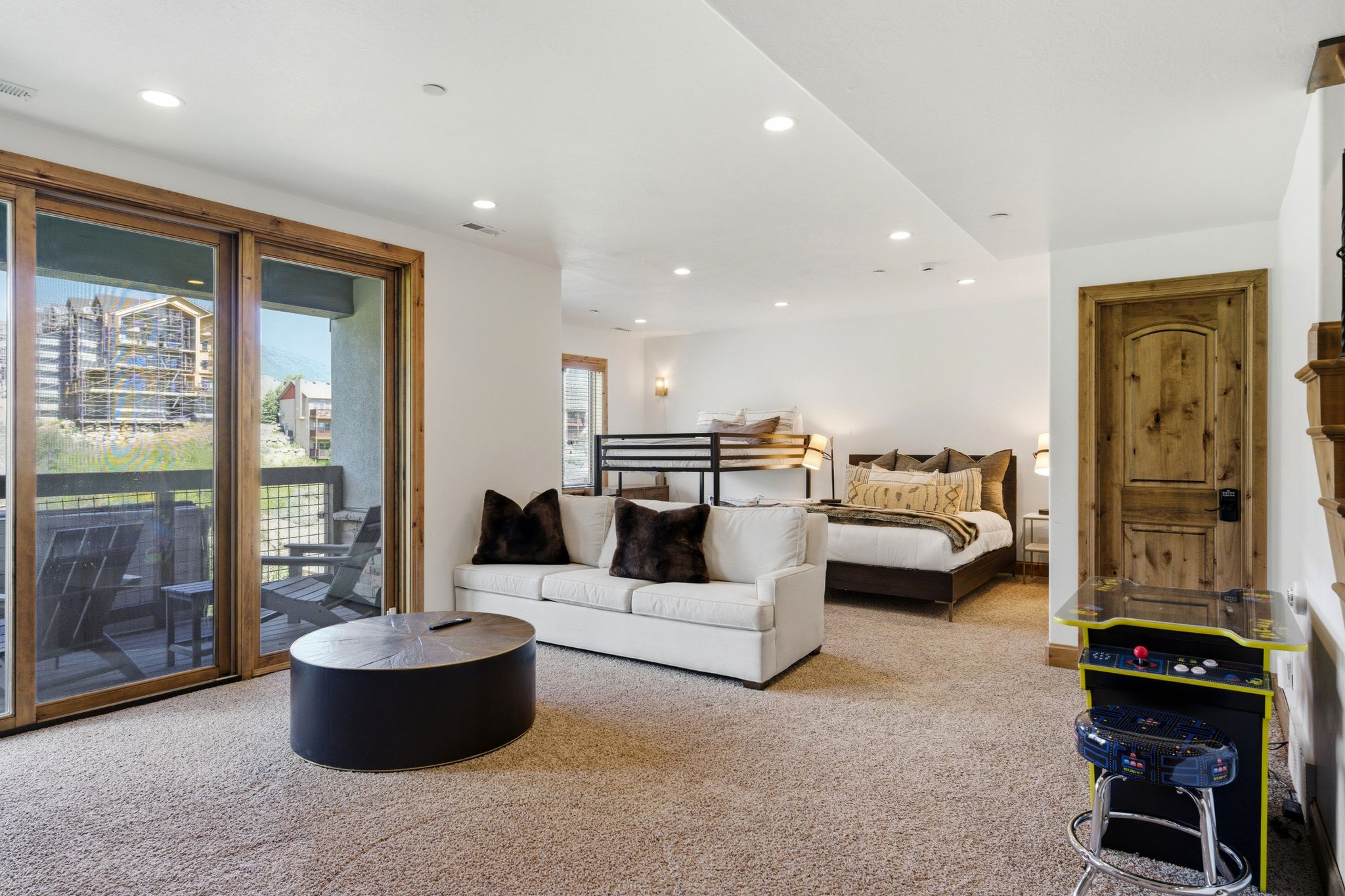 Spacious multi-functional room with wood-frame sliding glass doors opening to an outdoor patio