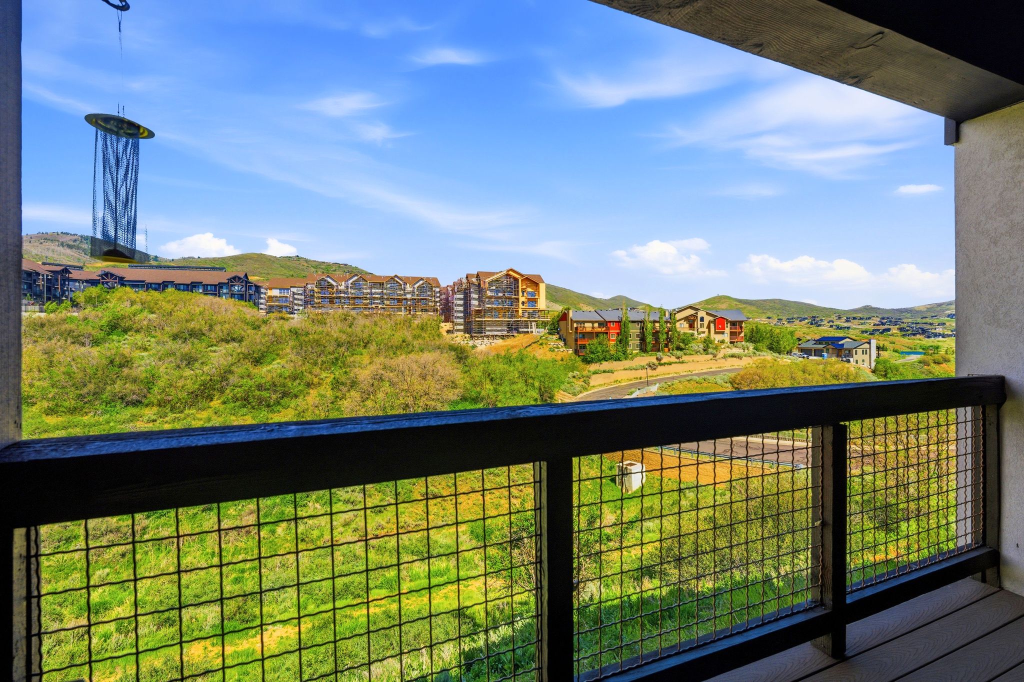 Outdoor balcony featuring a metal grid railing system and wood-finish flooring