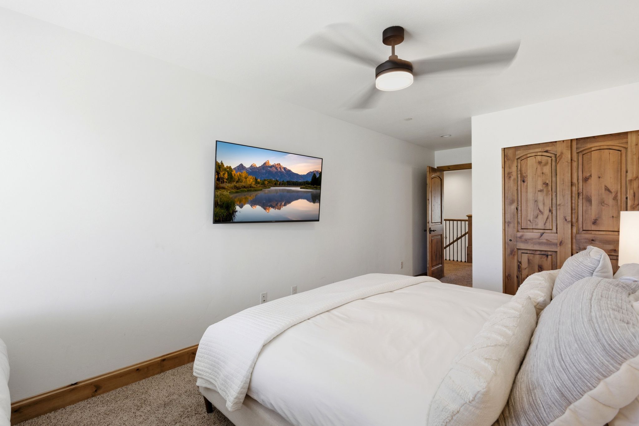 Bedroom with white walls, a ceiling fan, and carpeted flooring