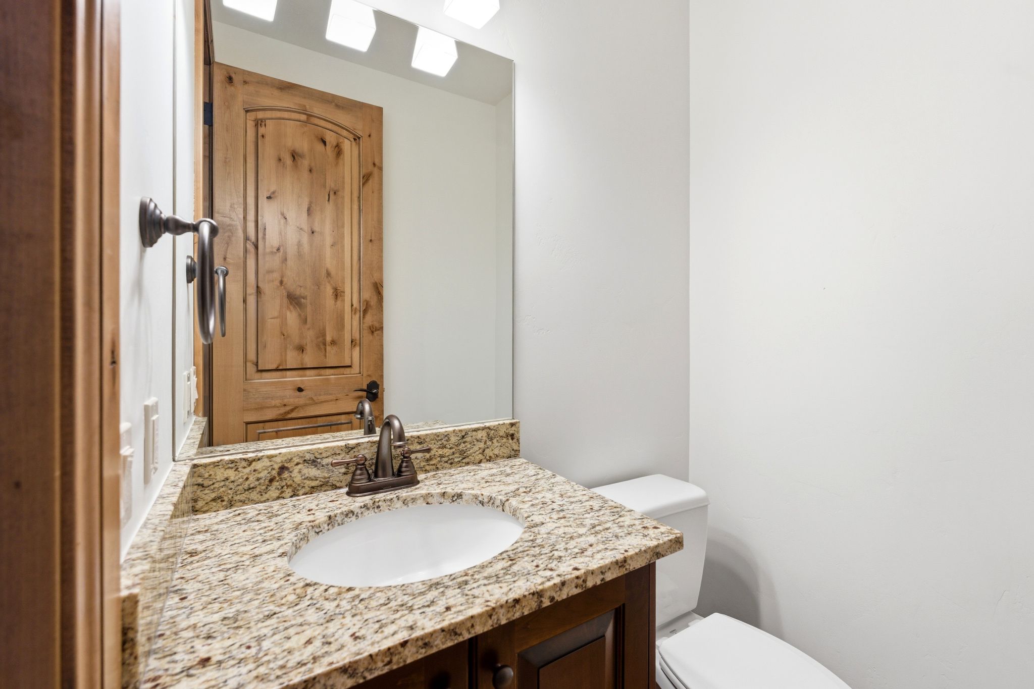 Bathroom vanity featuring a granite countertop with an undermount sink
