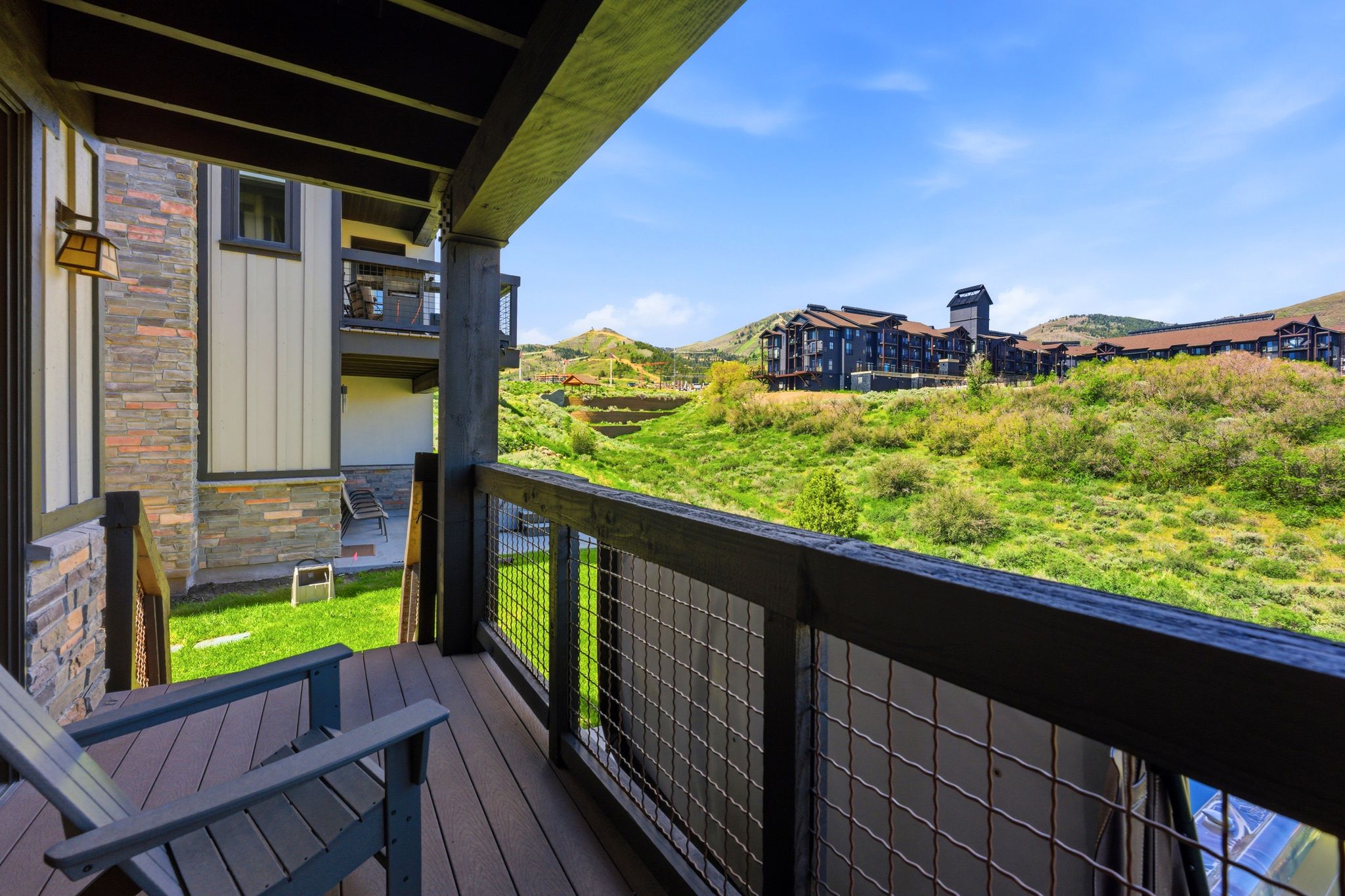 Private balcony featuring composite decking and a wire mesh railing