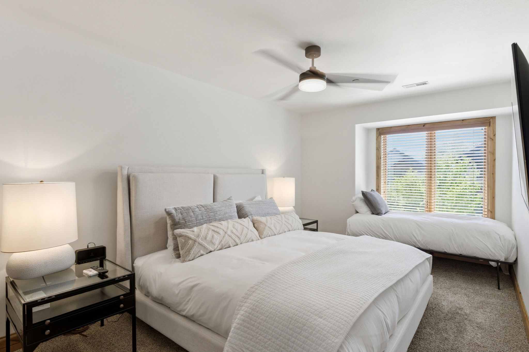 Spacious room with white walls and soft gray carpeting