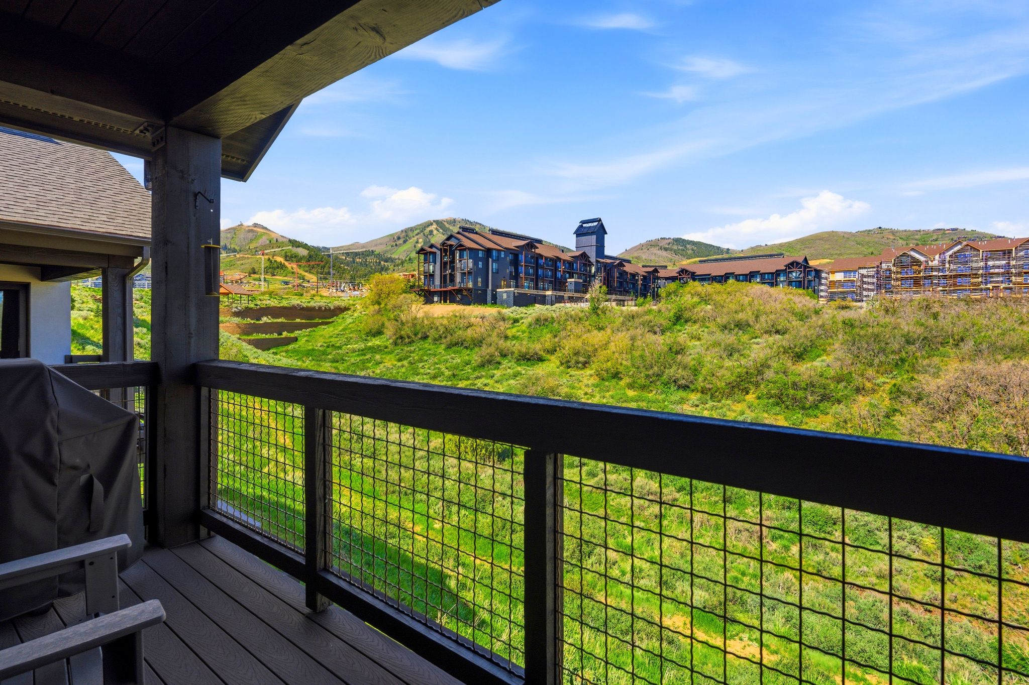 Covered balcony featuring wood-finish flooring and a metal grid railing