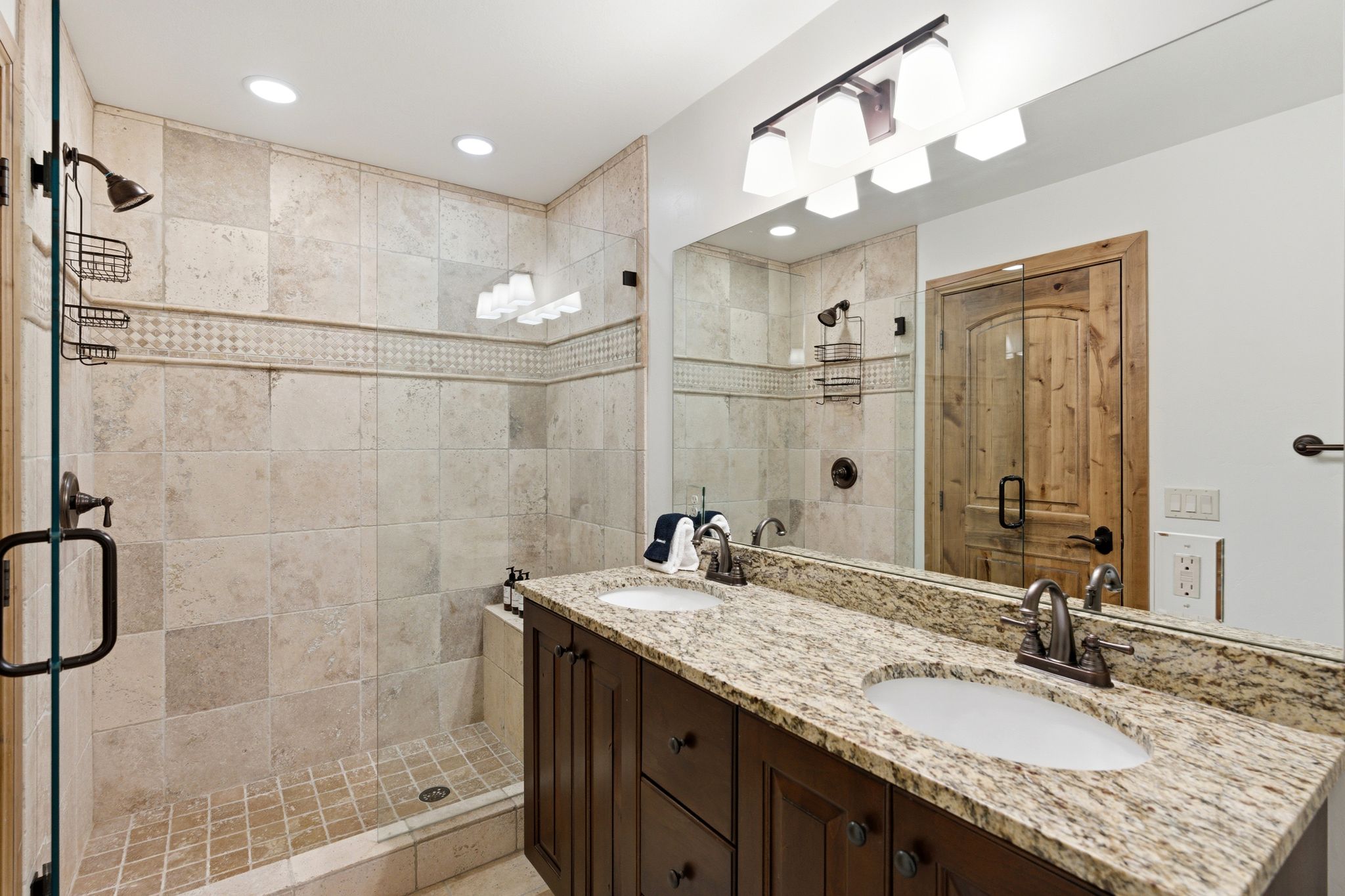 Spacious bathroom featuring a dual vanity with a granite countertop and undermount sinks