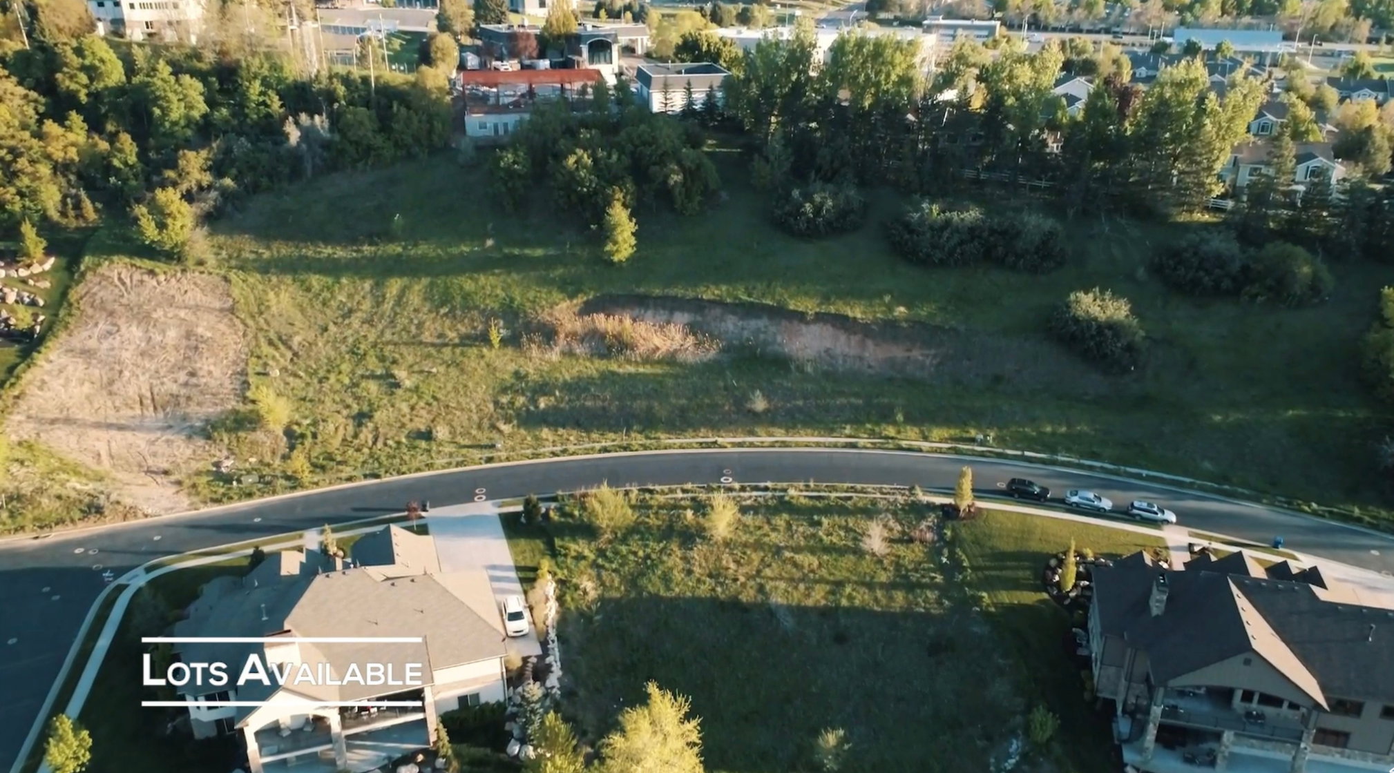 Expansive cleared lot featuring a gentle slope and surrounding residential properties