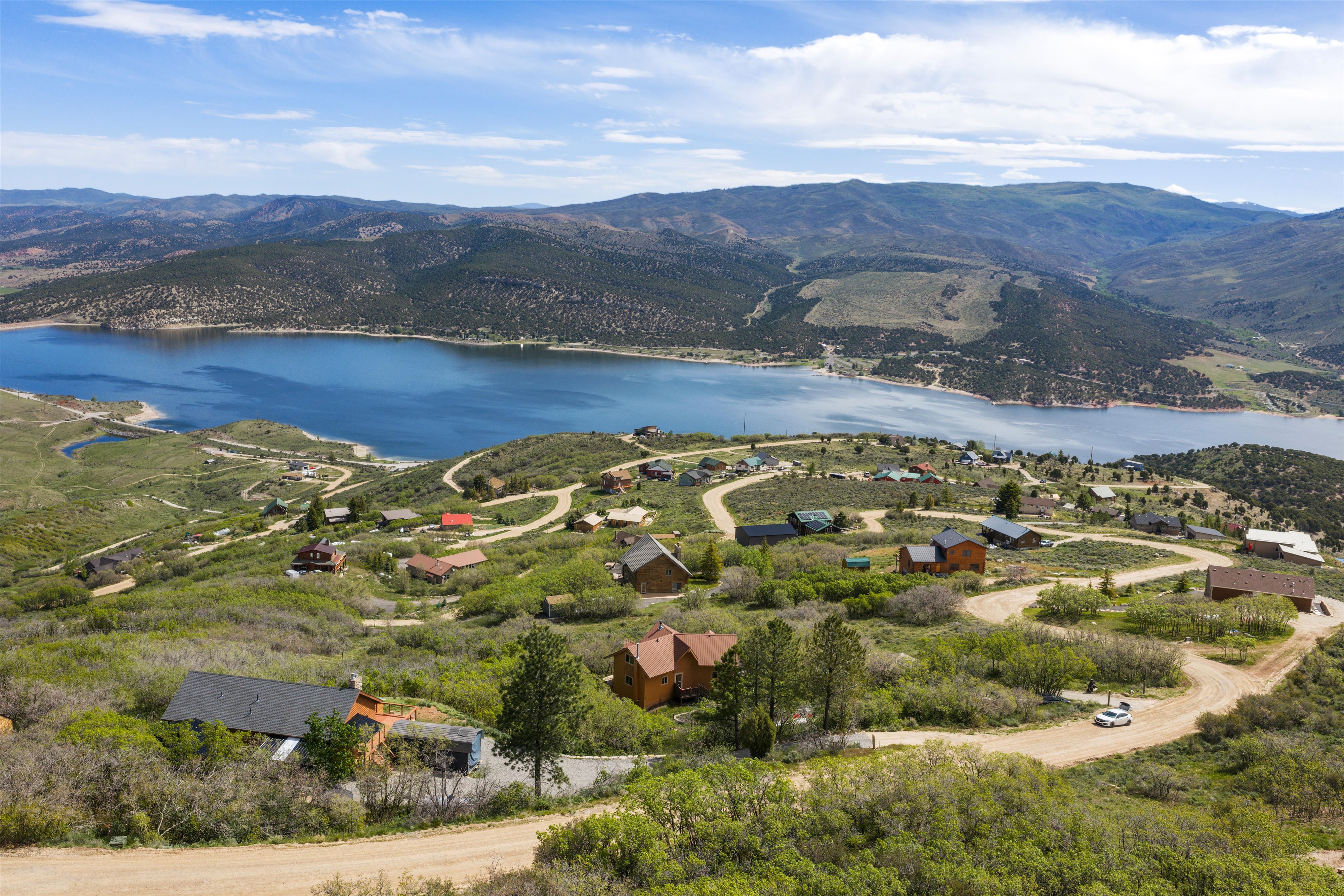 Aerial perspective showcasing a sprawling landscape with a prominent lake and surrounding mountains