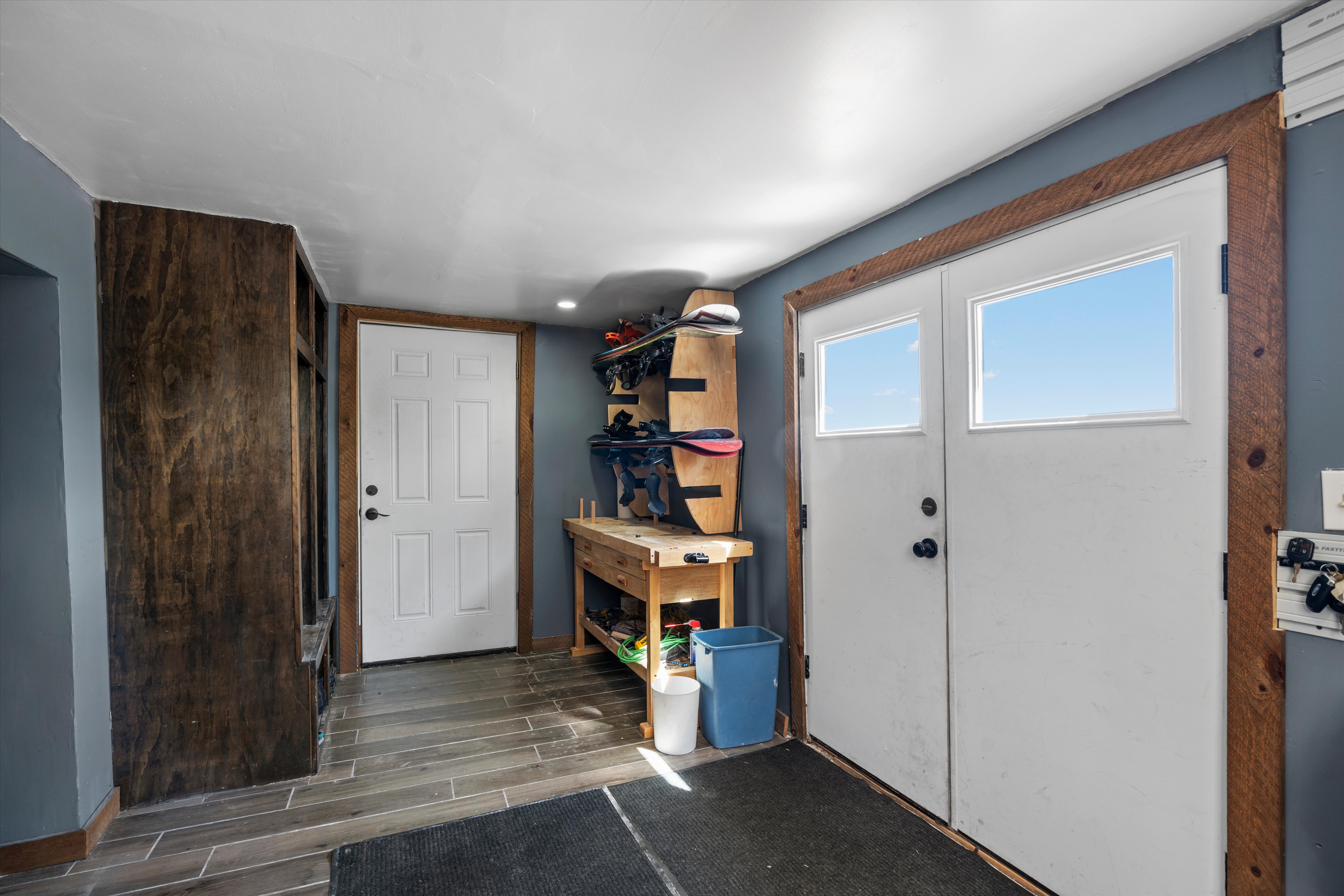 Entryway featuring double doors with transom windows, wood-finish flooring, and a built-in storage unit
