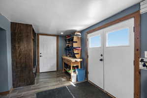 Entryway featuring double doors with transom windows, wood-finish flooring, and a built-in storage unit