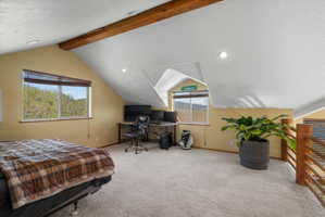 Carpeted loft space featuring exposed wood ceiling beams, sloped ceilings, recessed lighting, and wood railing