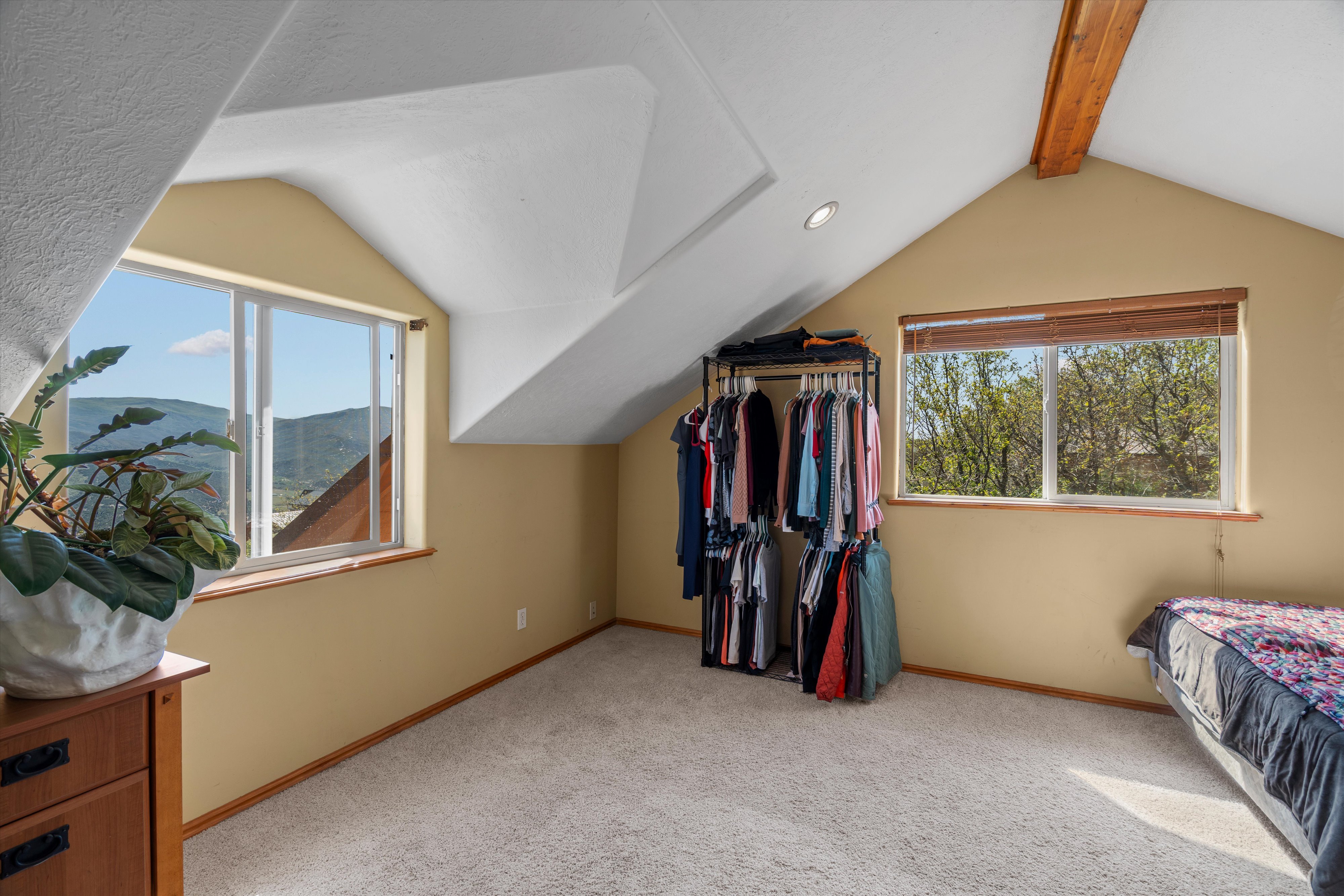 Attic room featuring a vaulted ceiling with exposed wood beam, recessed lighting, and soft carpet flooring