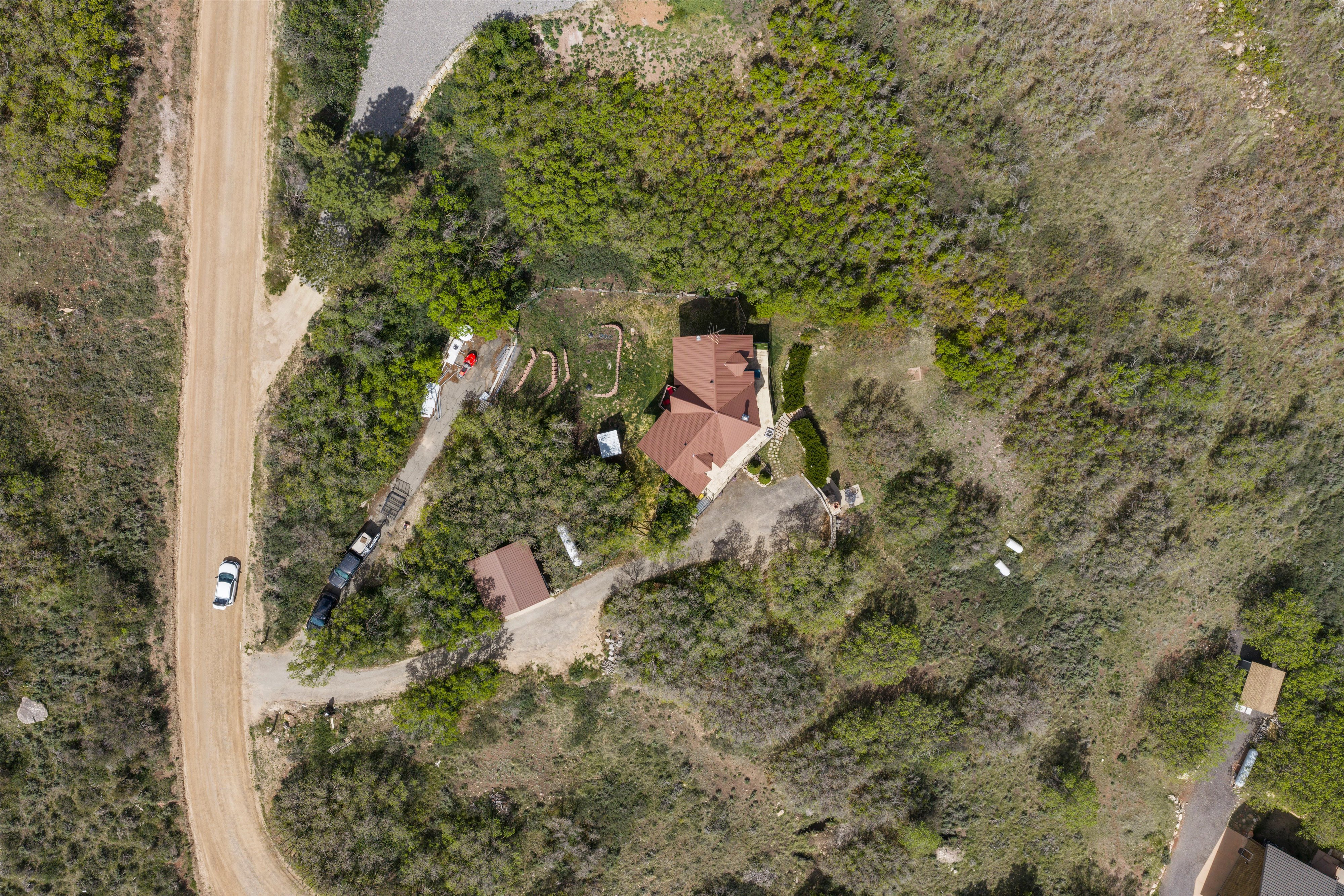 Aerial overview showcasing a secluded property with a main residence and a detached garage