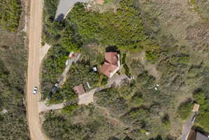 Aerial overview showcasing a secluded property with a main residence and a detached garage