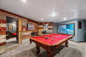 Entertainment space featuring a billiards table with a red felt surface, textured Barn wood-finish wall paneling, recessed lighting, and carpet flooring