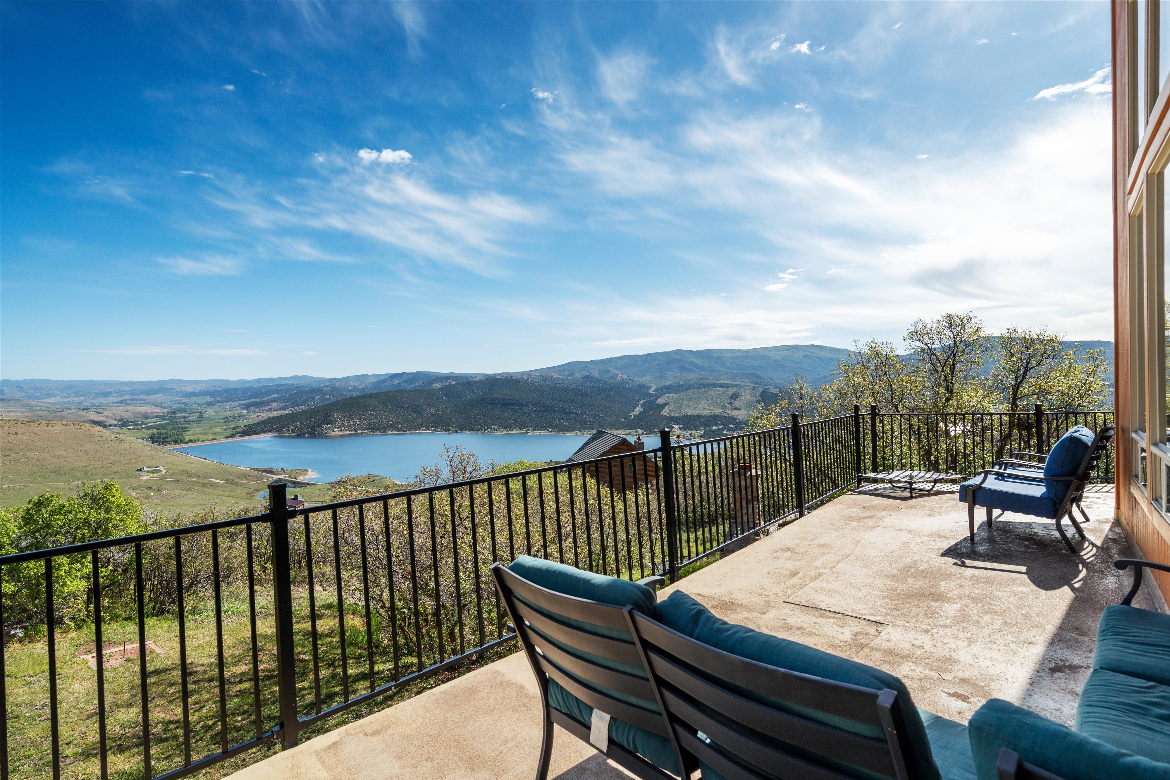 Wrap around patio featuring a black metal railing and expansive water and mountain scenery