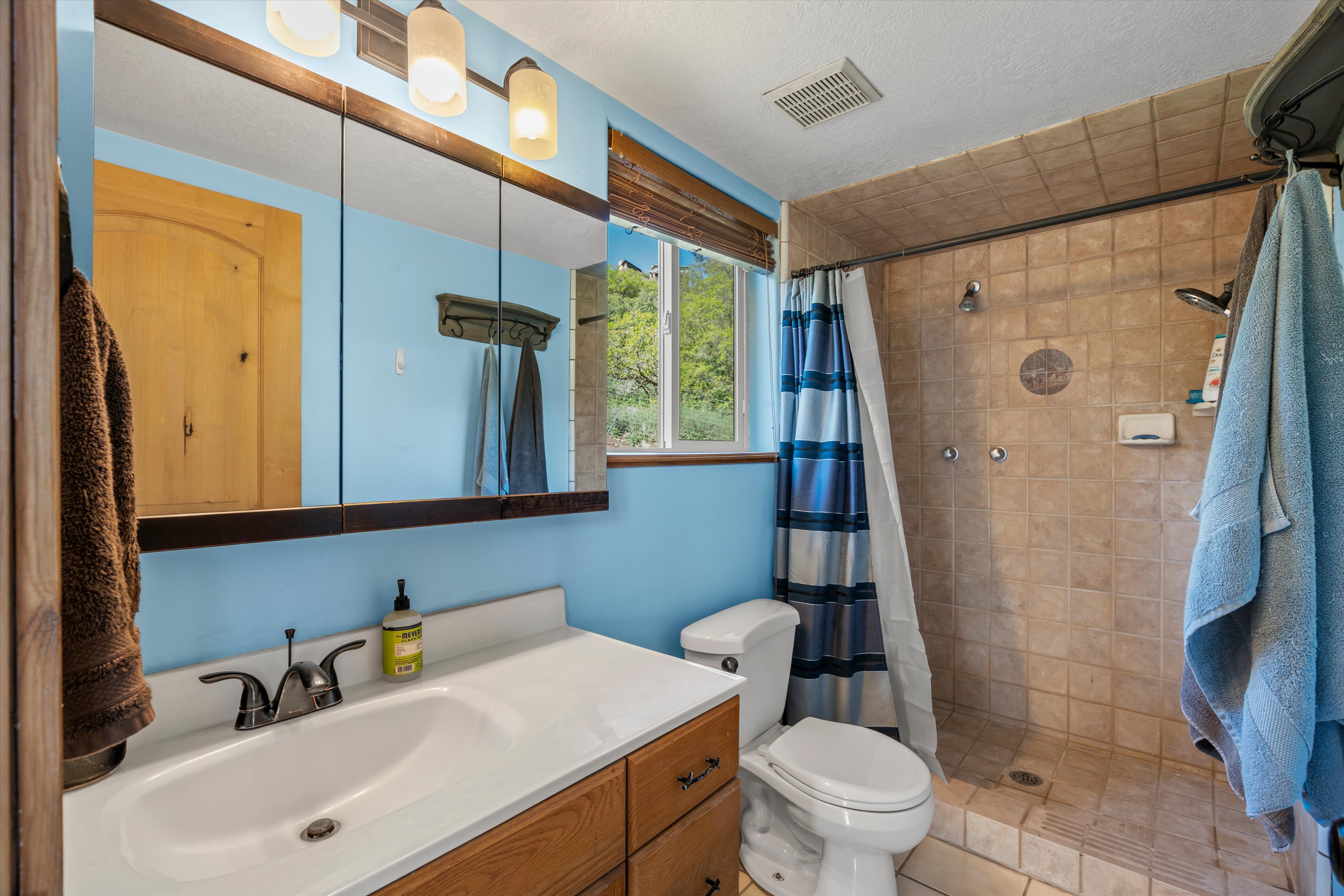 Bathroom vanity with a white countertop and wood-finish cabinetry