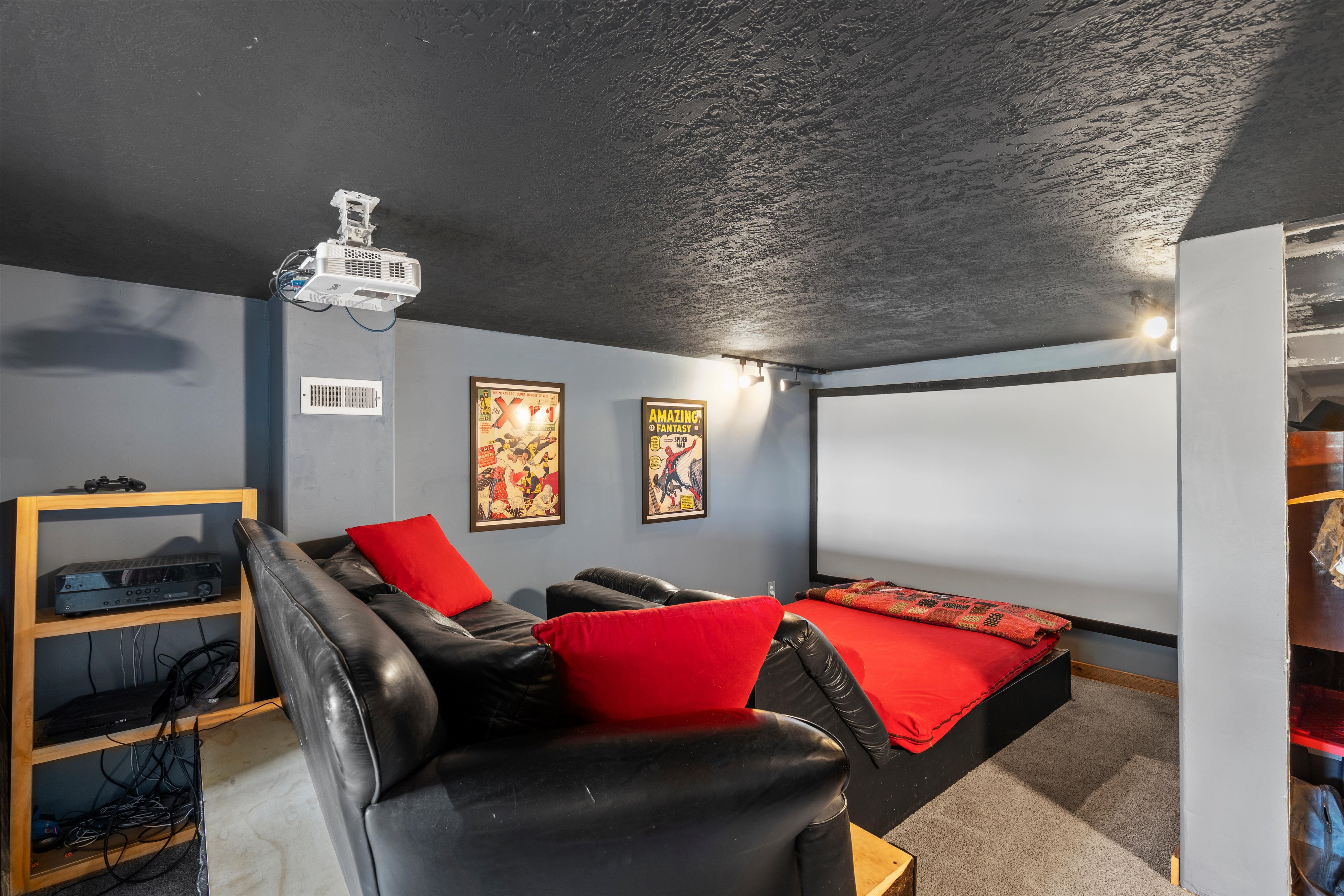 Dedicated media room featuring a large projection screen and ceiling-mounted projector