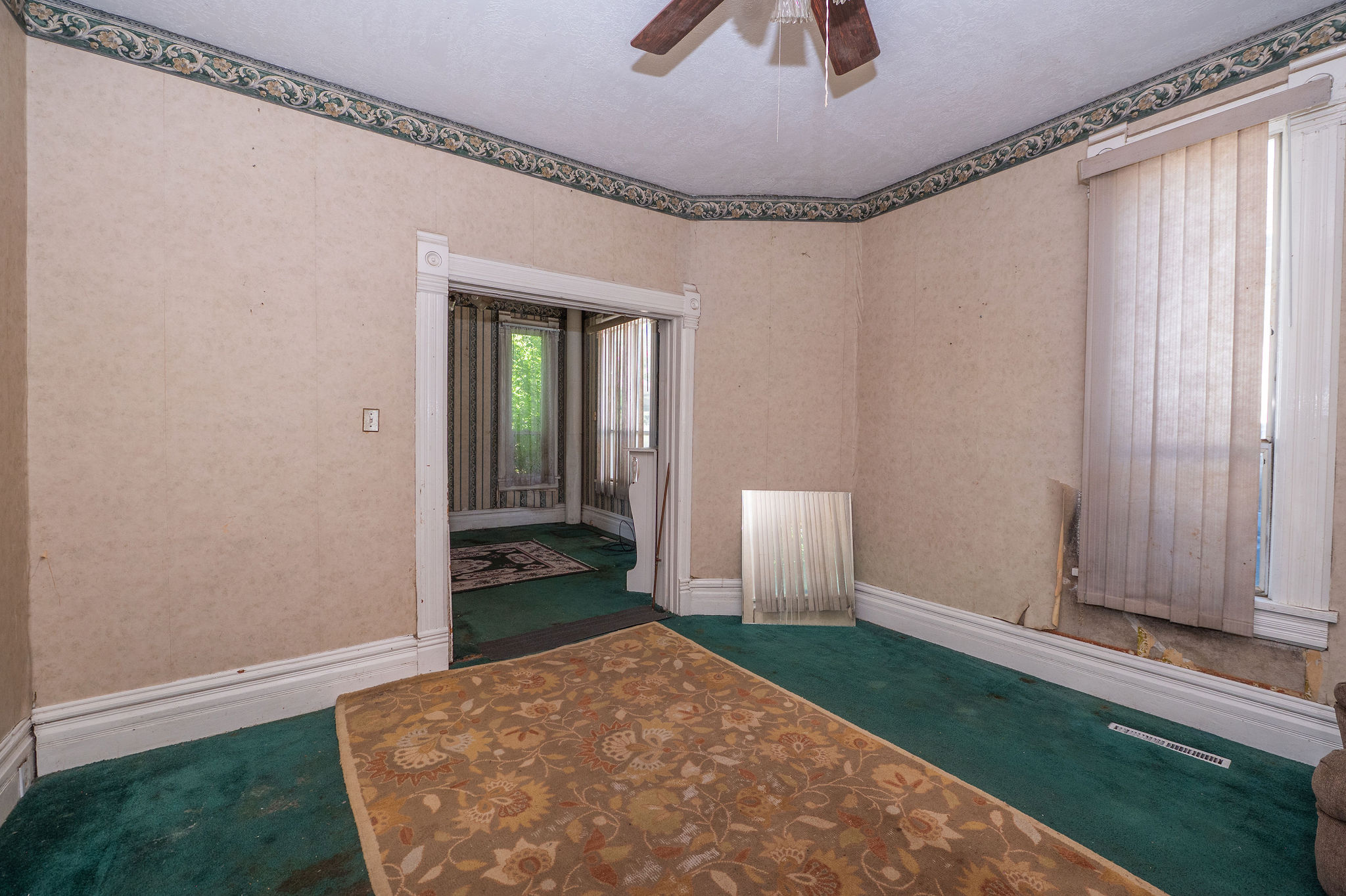 Room featuring a wide archway and textured wallpaper with a decorative border