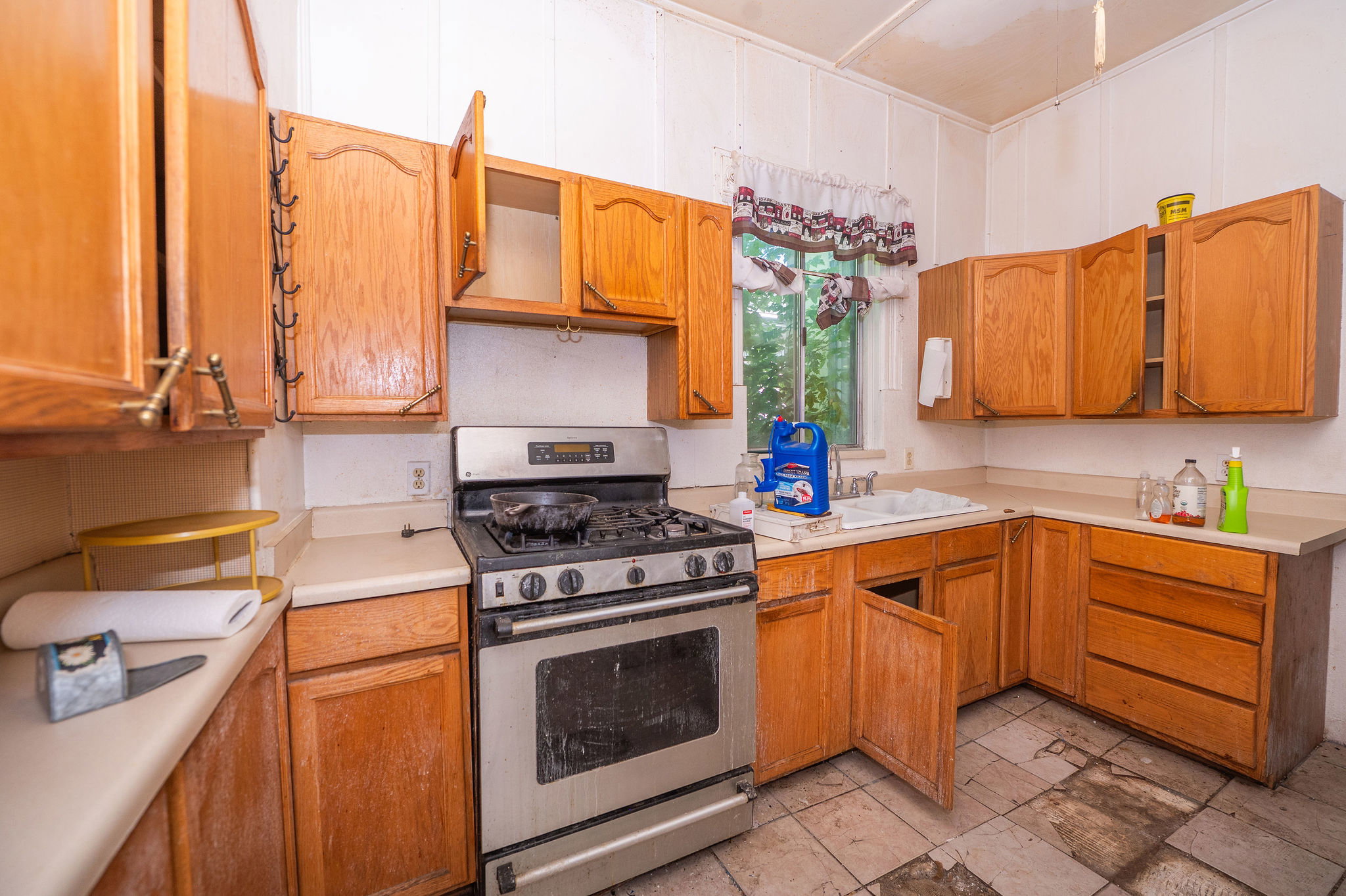 Kitchen featuring wood-finish cabinetry, light-toned countertops, and a stainless steel range