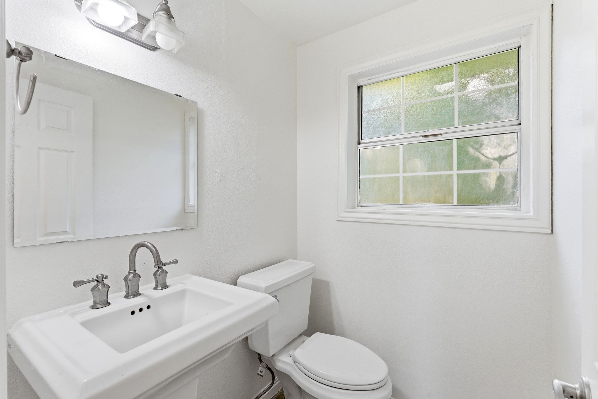 Main level 1/2 bathroom with pedestal sink.