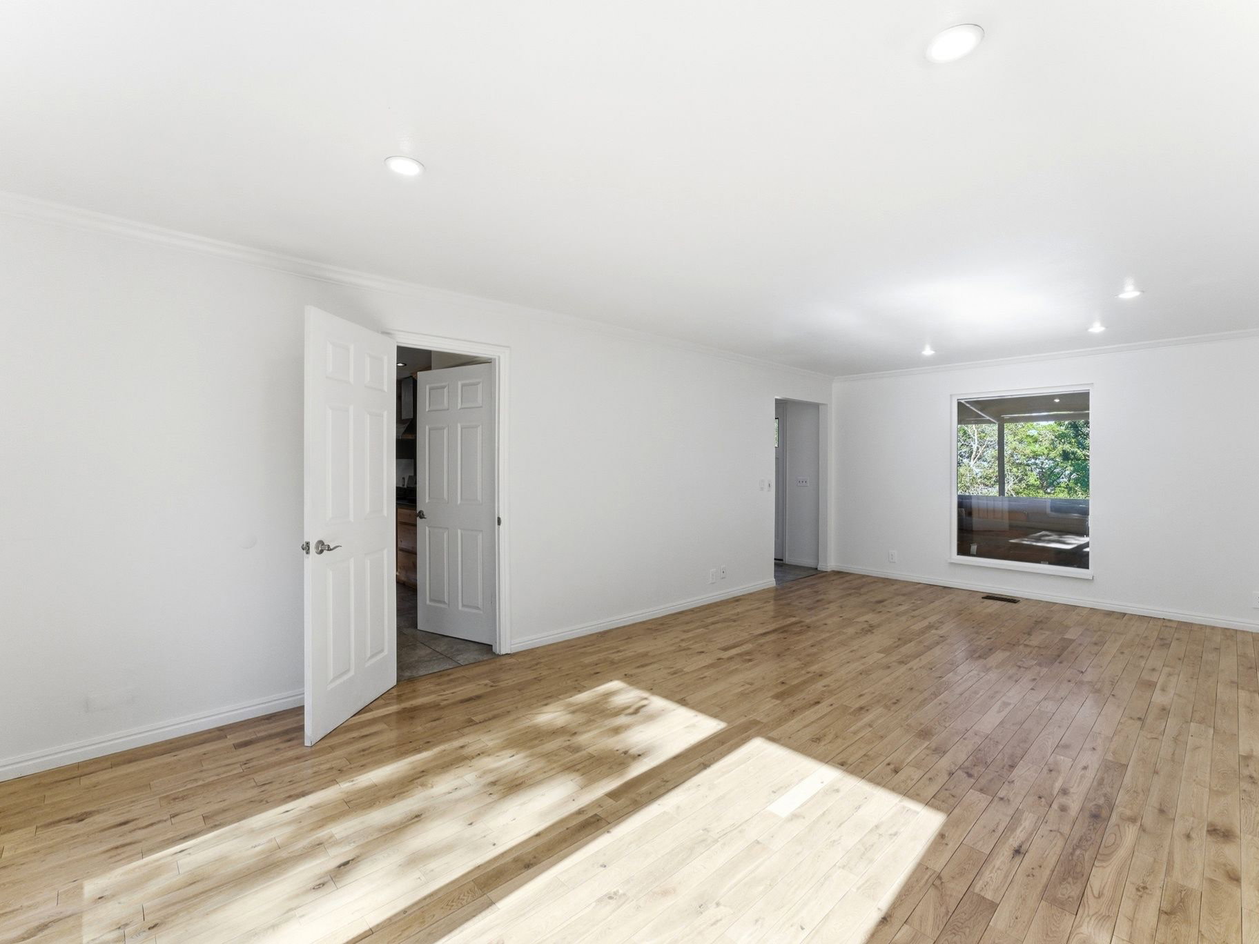 Spacious living room with access to kitchen and entryway