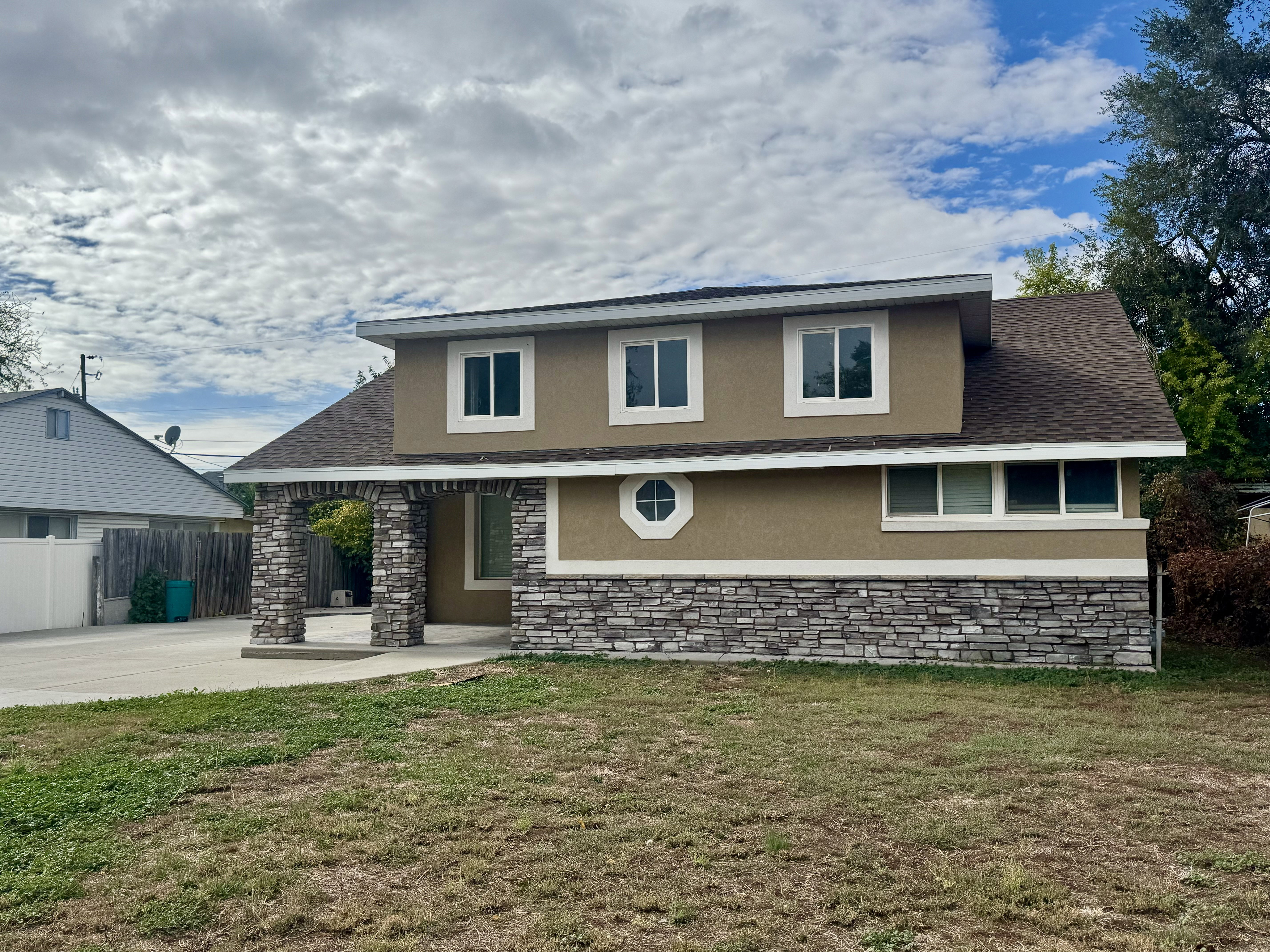 Front with Stucco and stone arches on porch