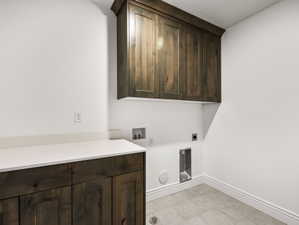 Utility room with dark wood-finish cabinetry, light-colored countertop, and tile flooring