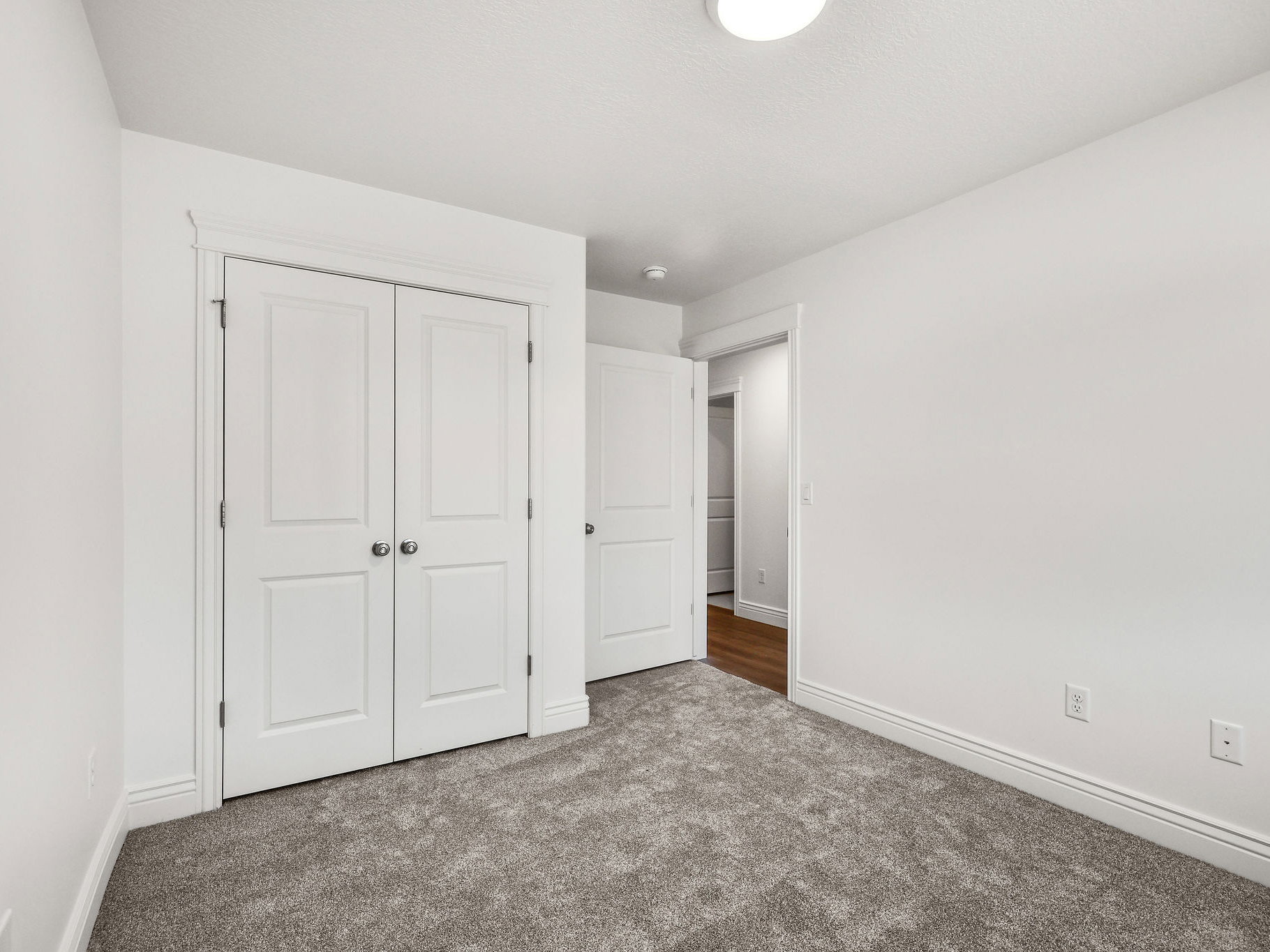 Room featuring textured carpeting, white walls, and white trim