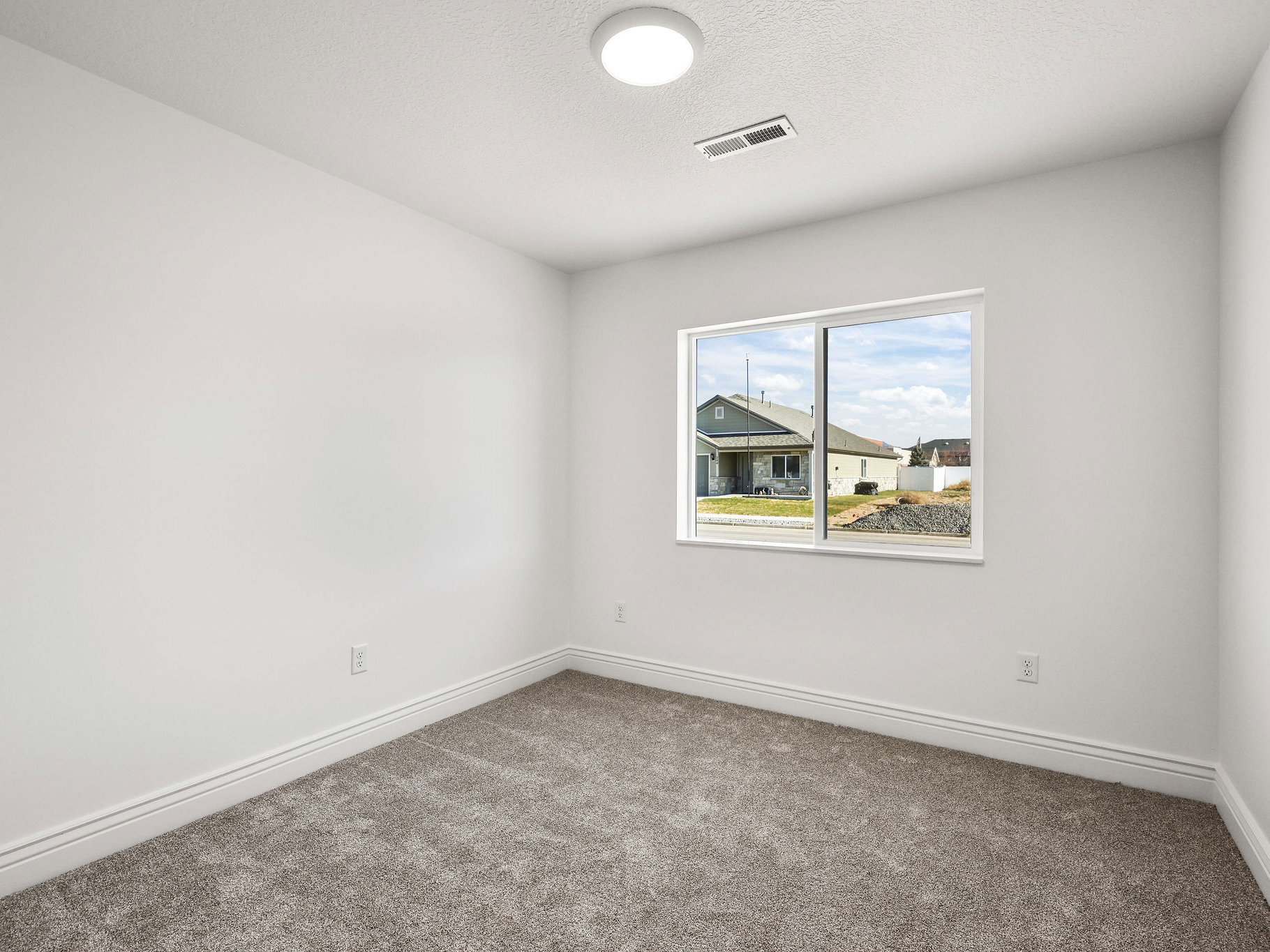 Neutral wall paint with carpet flooring, a window, and a ceiling light fixture