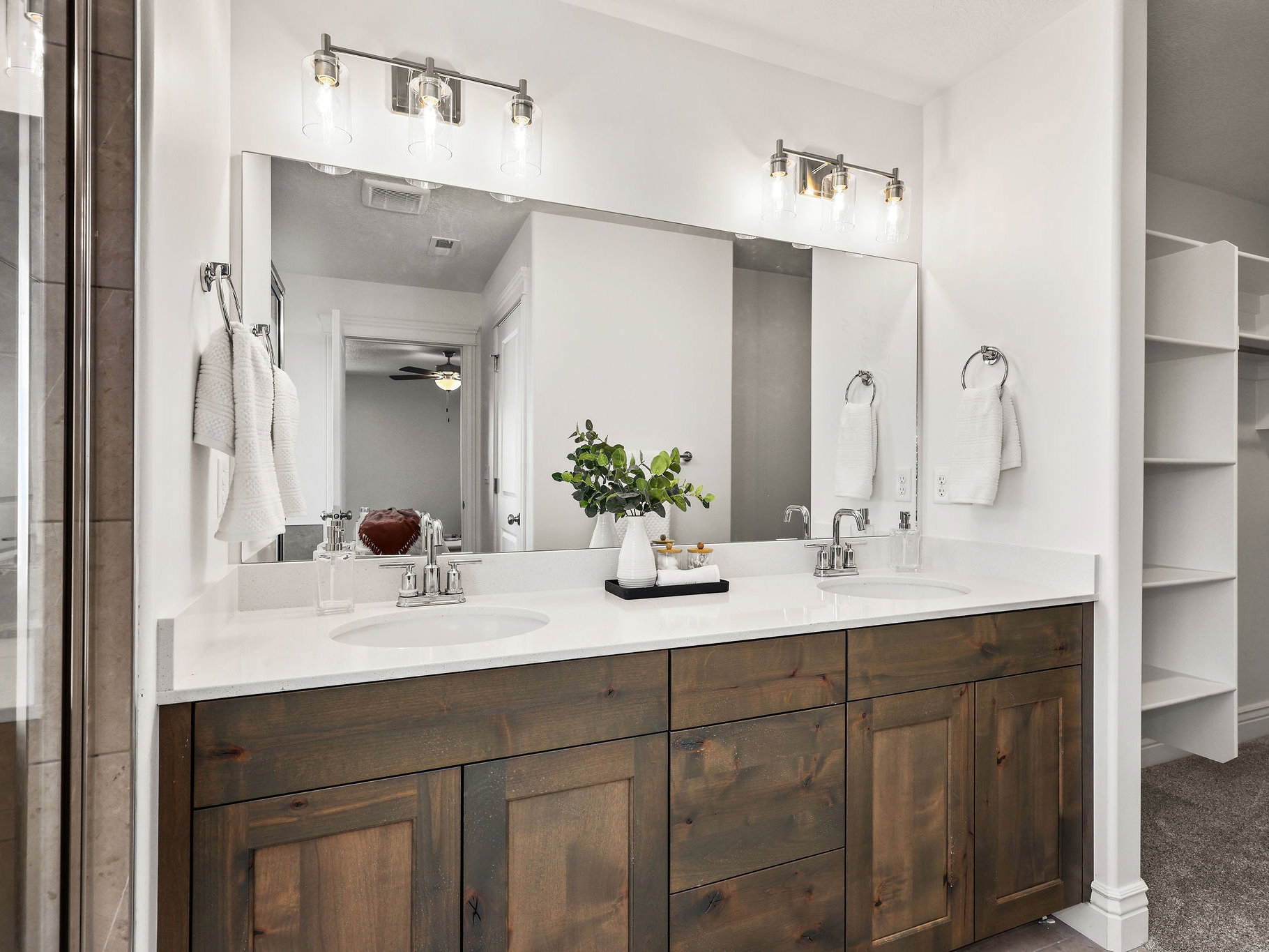 Dual vanity featuring wood-finish cabinetry, white countertops, and undermount sinks
