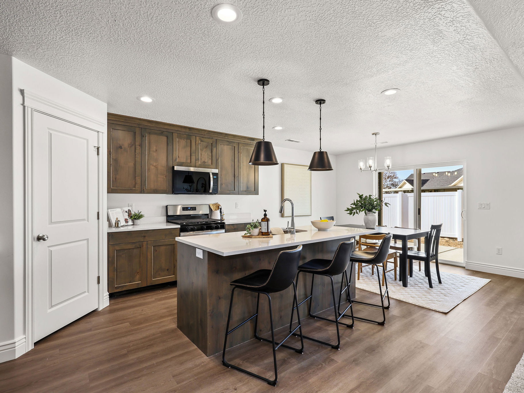 Kitchen featuring a center island with countertop seating, wood-finish flooring, stainless steel appliances, and wood cabinetry