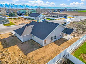 Newly constructed residence with a light-colored stucco exterior and dark-shingled roof