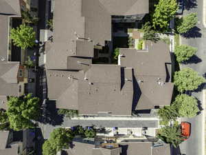 Aerial perspective showcasing a complex of buildings with various rooflines and brown asphalt shingle roofs