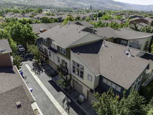 Multi-level townhome featuring a neutral-toned exterior with dark green and blue accents
