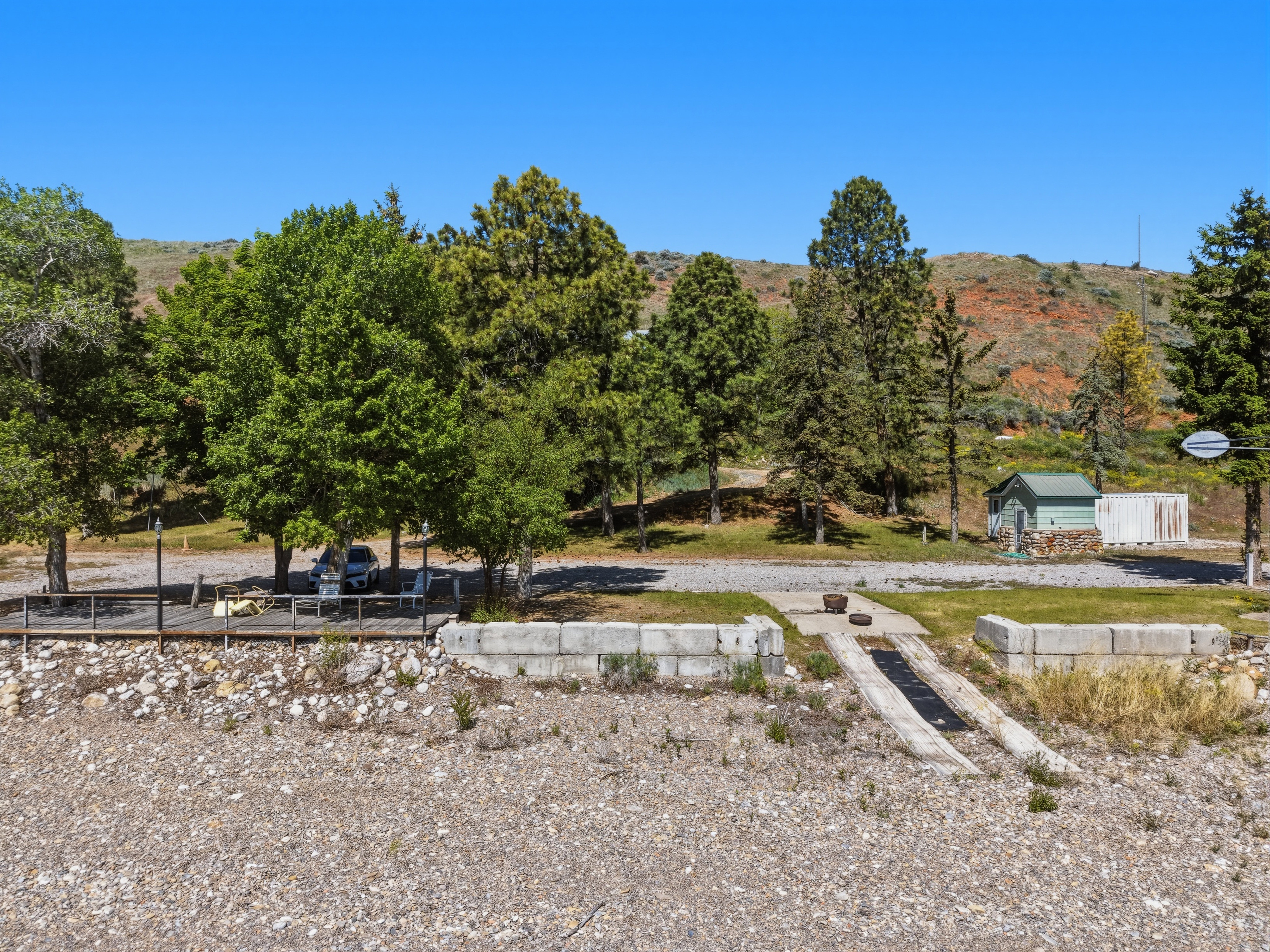Gravel shoreline featuring a concrete boat ramp and timber decking