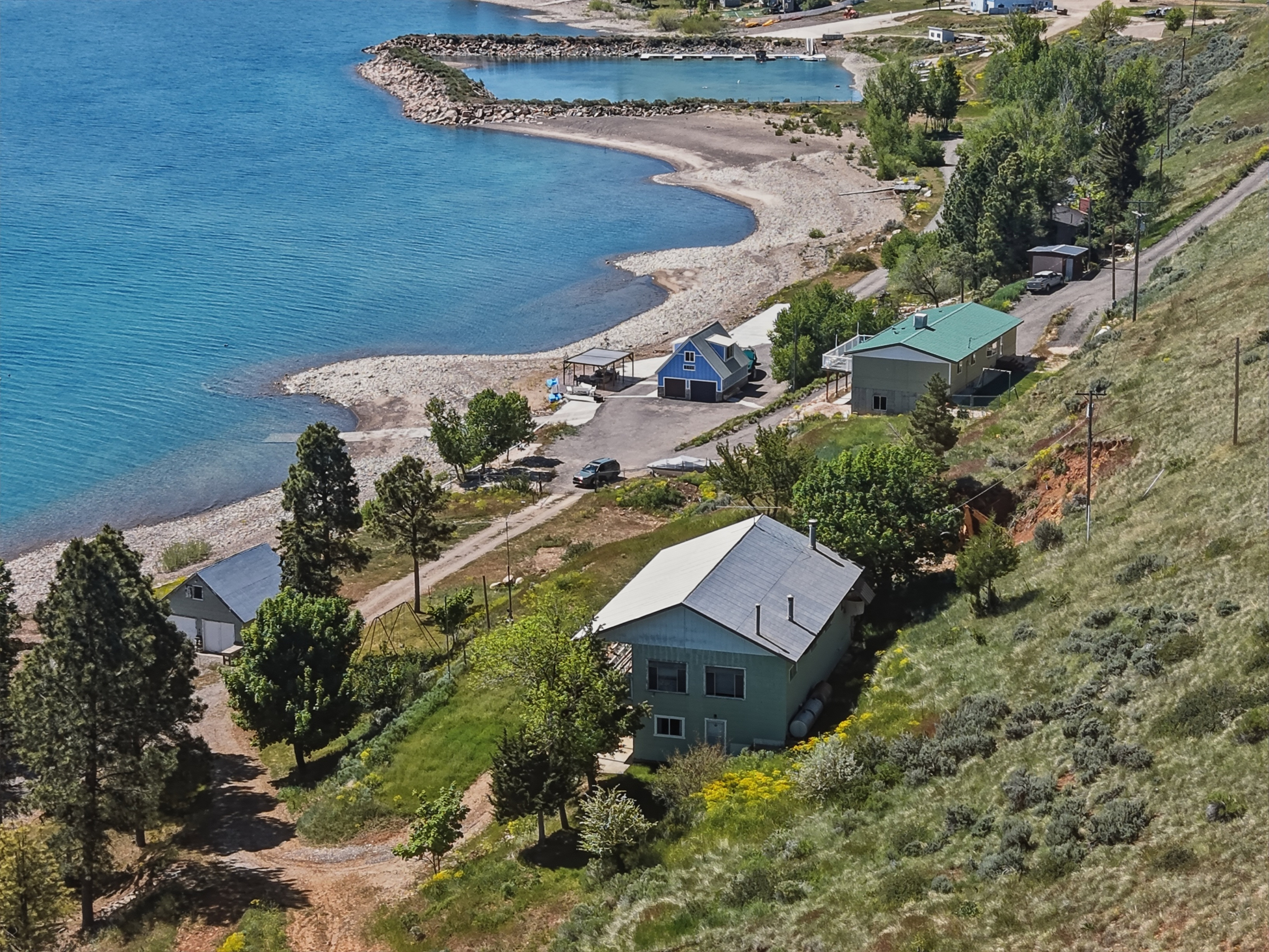 Property with direct water frontage, featuring a private beach and boat launch area