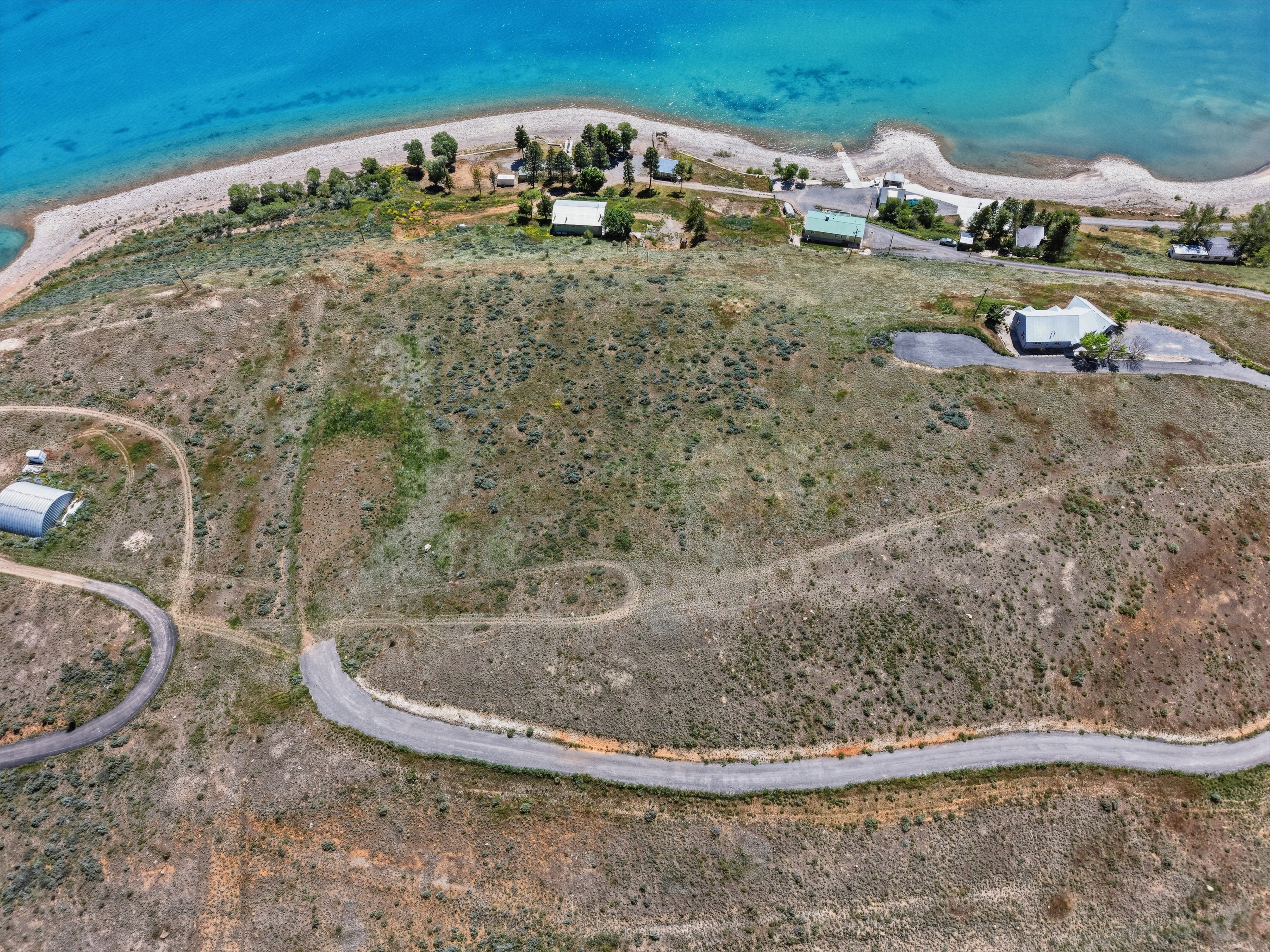 Aerial perspective showcasing extensive undeveloped land with a winding paved road