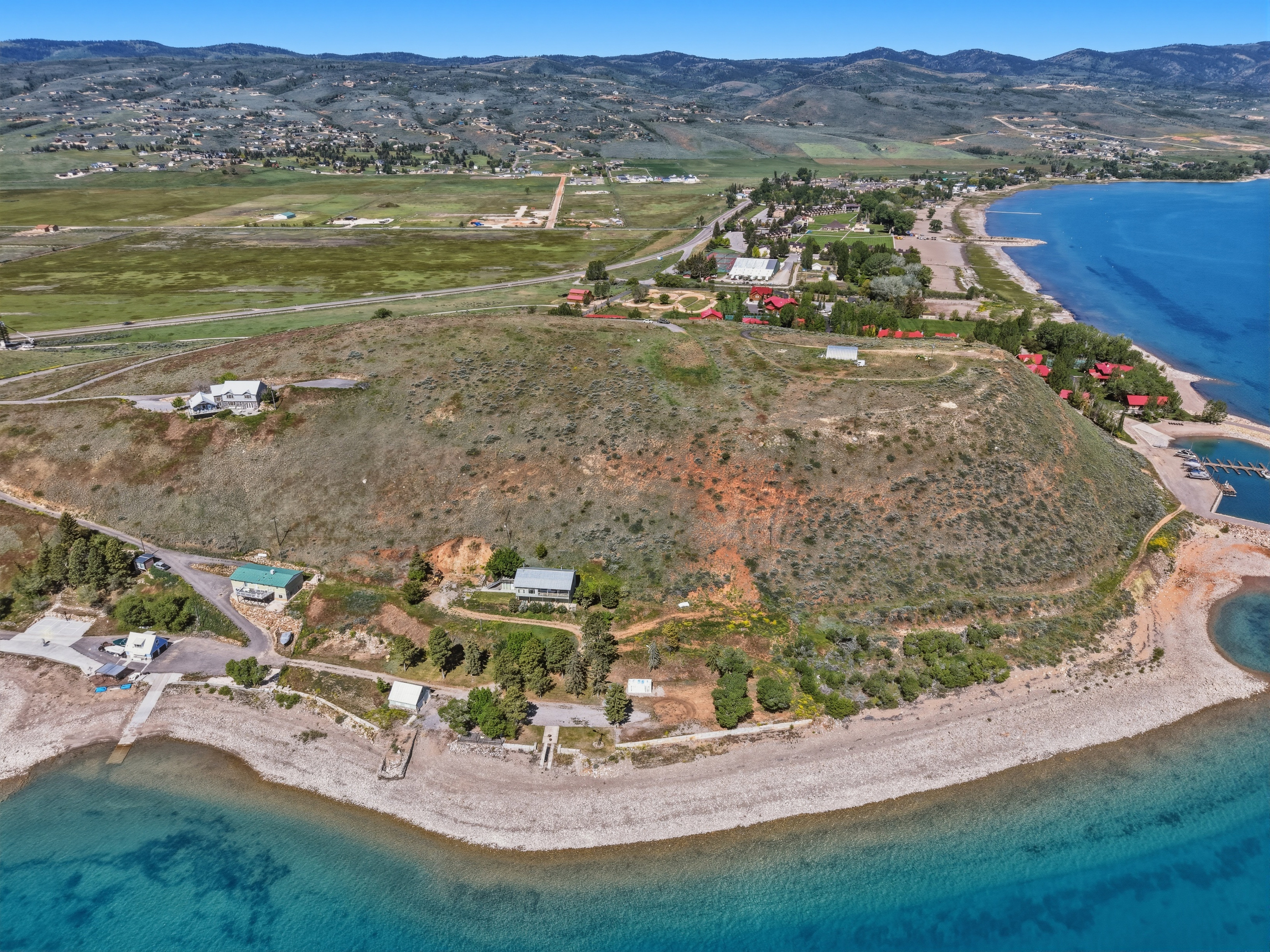 Expansive waterfront property featuring direct lake access, multiple residential structures, and a natural, varied landscape