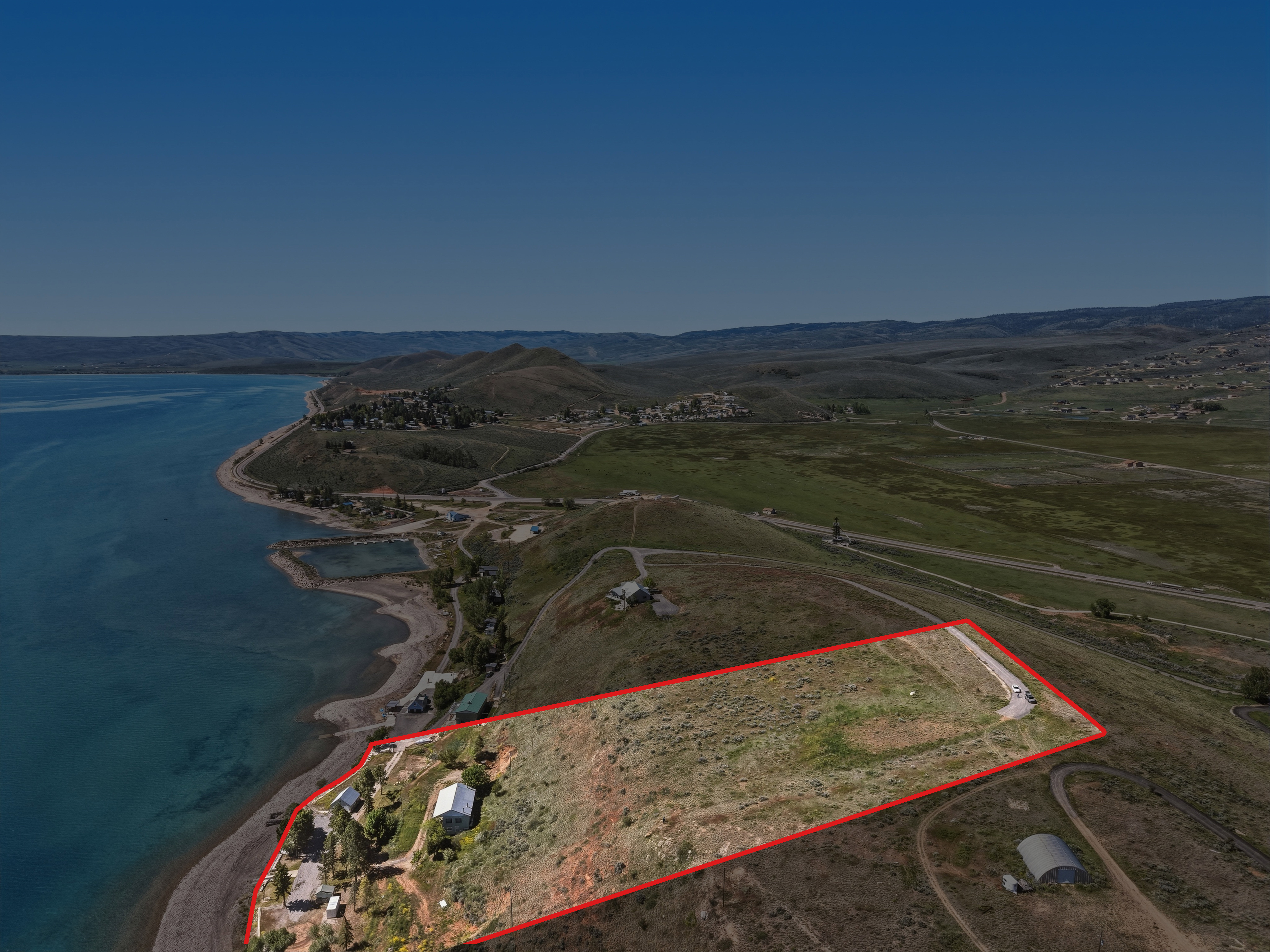 Expansive waterfront property featuring a large land parcel, direct lake access, and a clear, open natural landscape