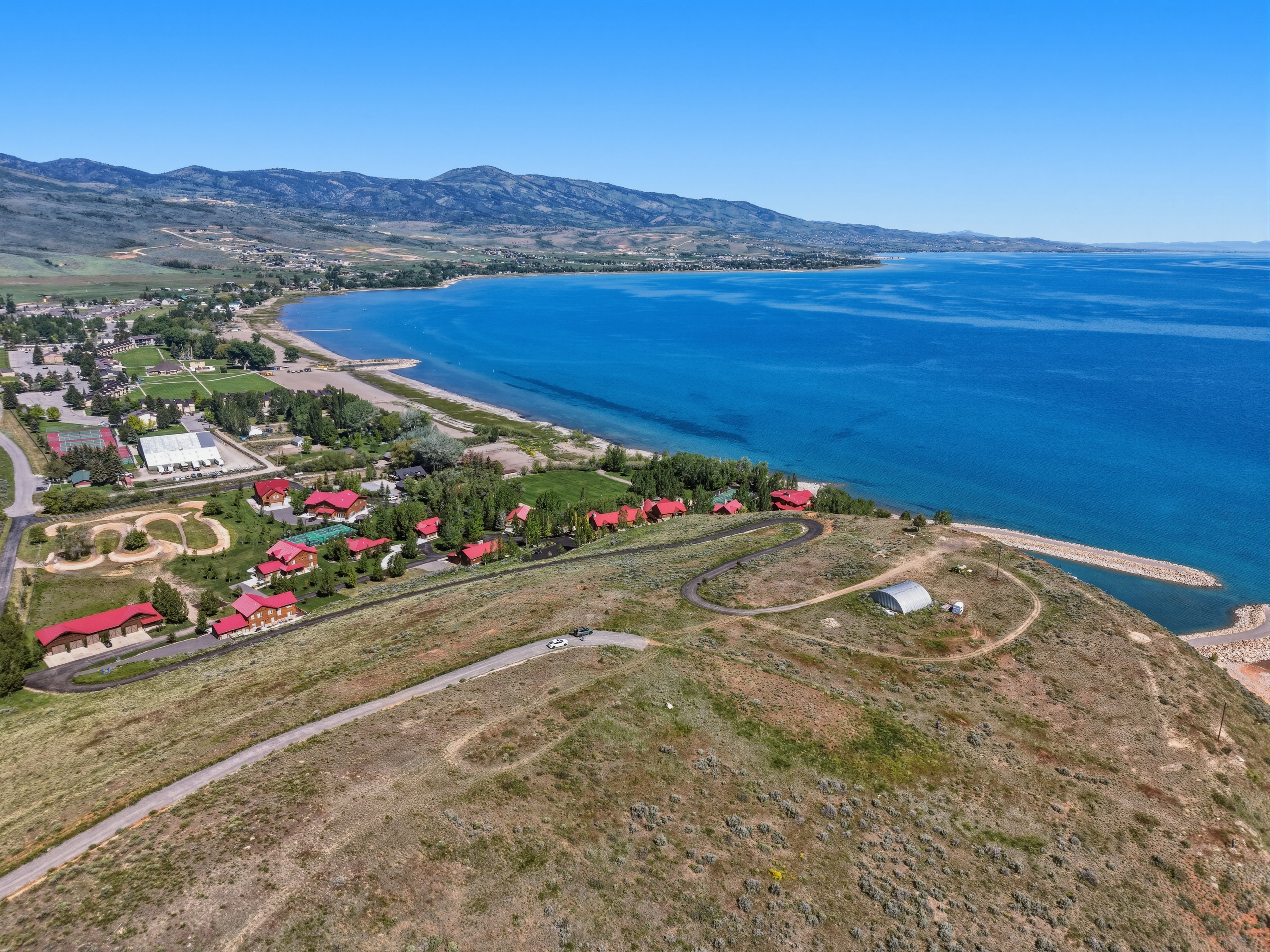 Expansive property offering extensive lake frontage, a private boat launch, and multiple structures with red roofs