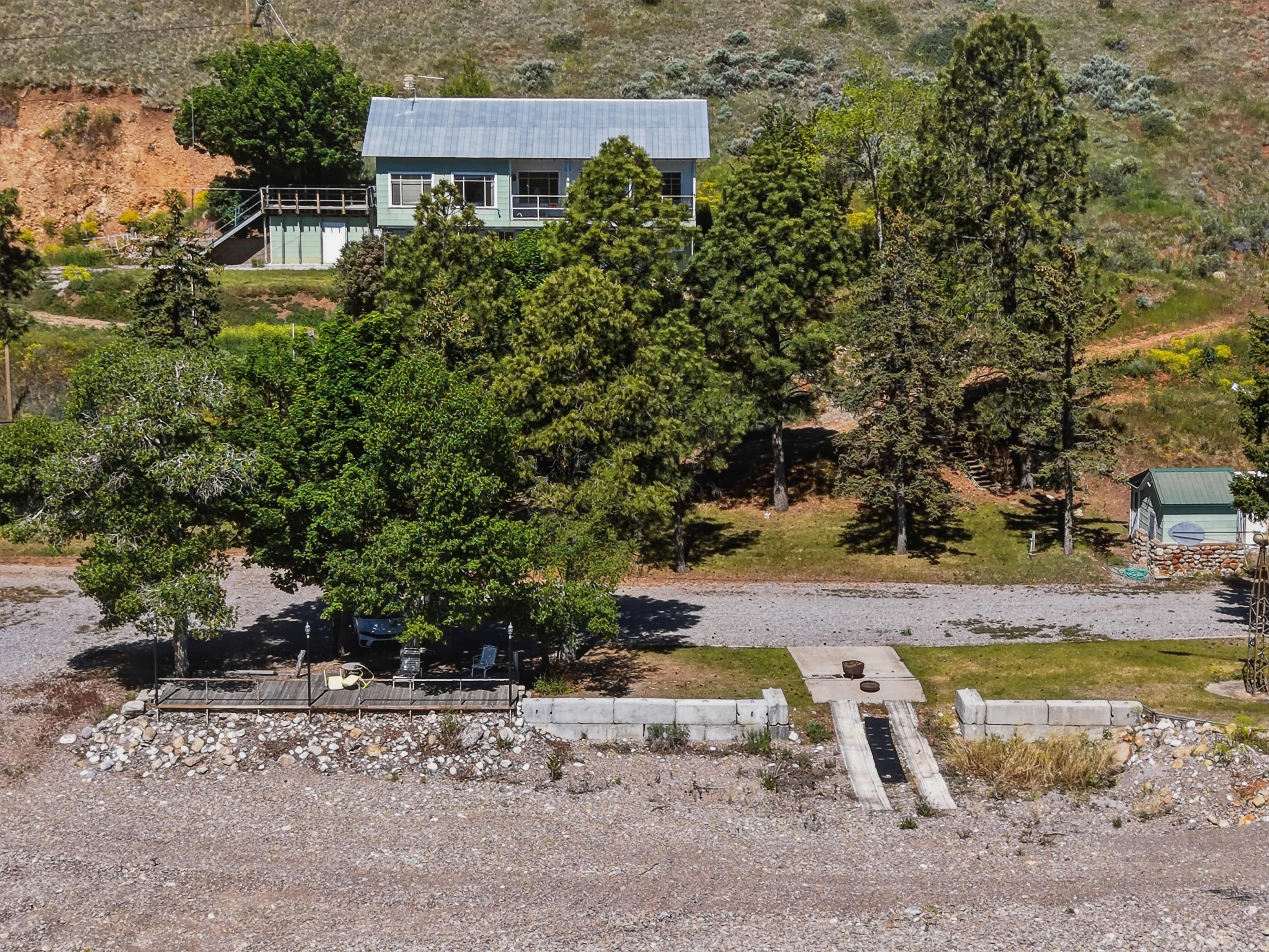 Hillside residence featuring a light green exterior with a metal roof
