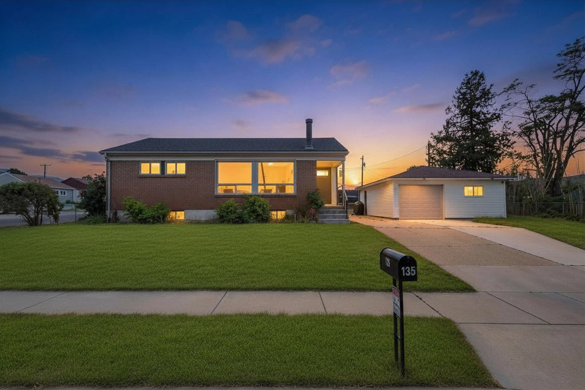 Brick exterior residence featuring a wide front lawn and a detached garage