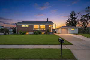 Brick exterior residence featuring a wide front lawn and a detached garage