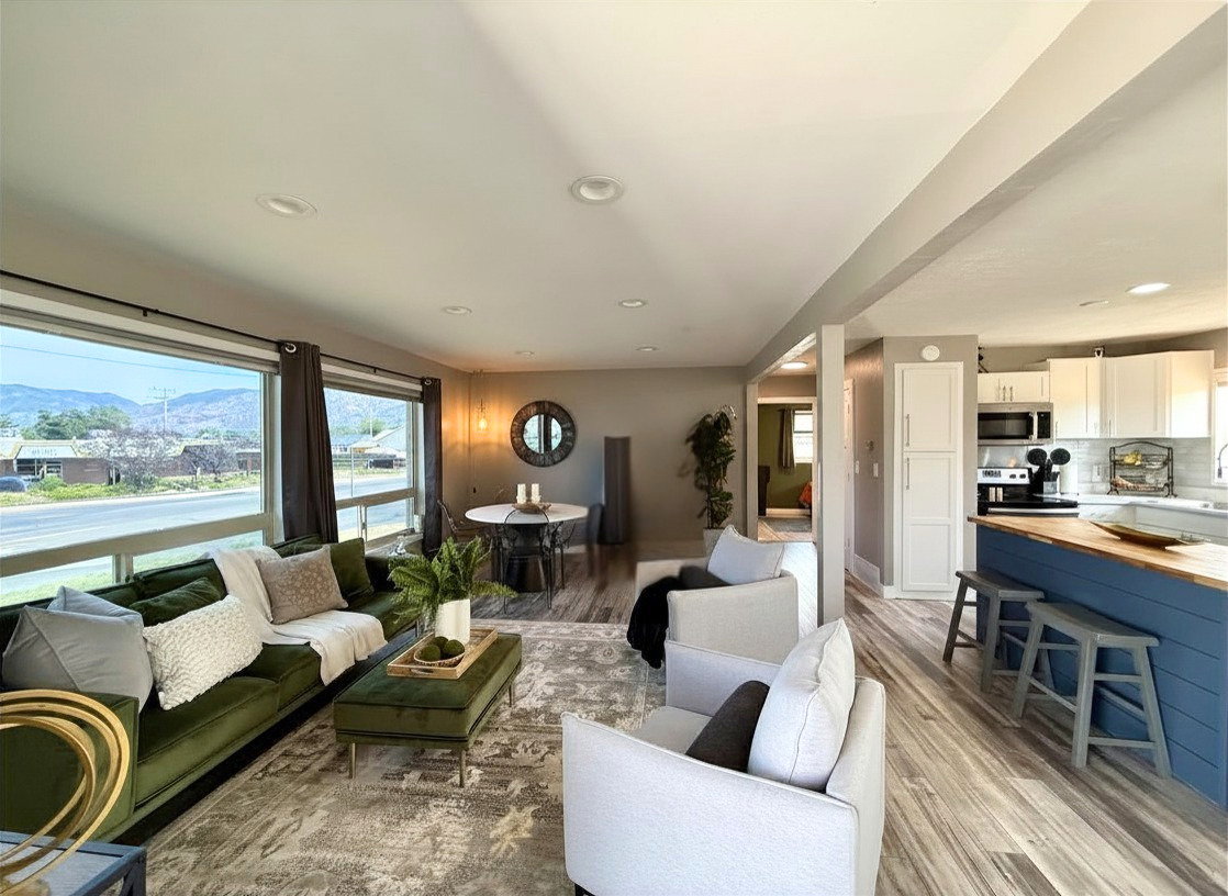 Expansive living area featuring large windows, recessed lighting, and wood-finish flooring