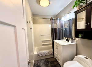 Bathroom featuring a white vanity with a rectangular sink, black faucet, and overhead three-bulb light fixture